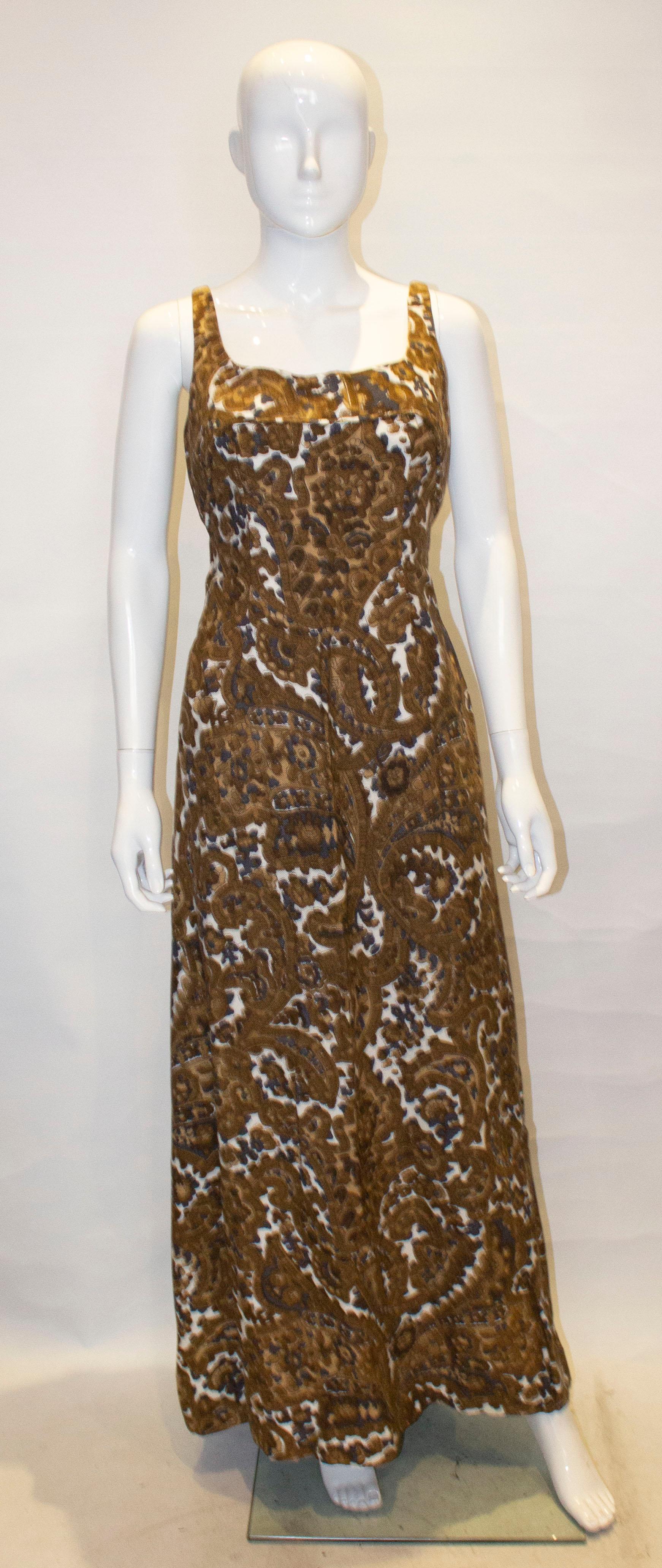 A great vintage gown by Jean Allen , London. In a quality linen, the dress is in a print of brown, white and blue with a scoop neckline and low backlline. The dress has two bows at the back and a back pleat.