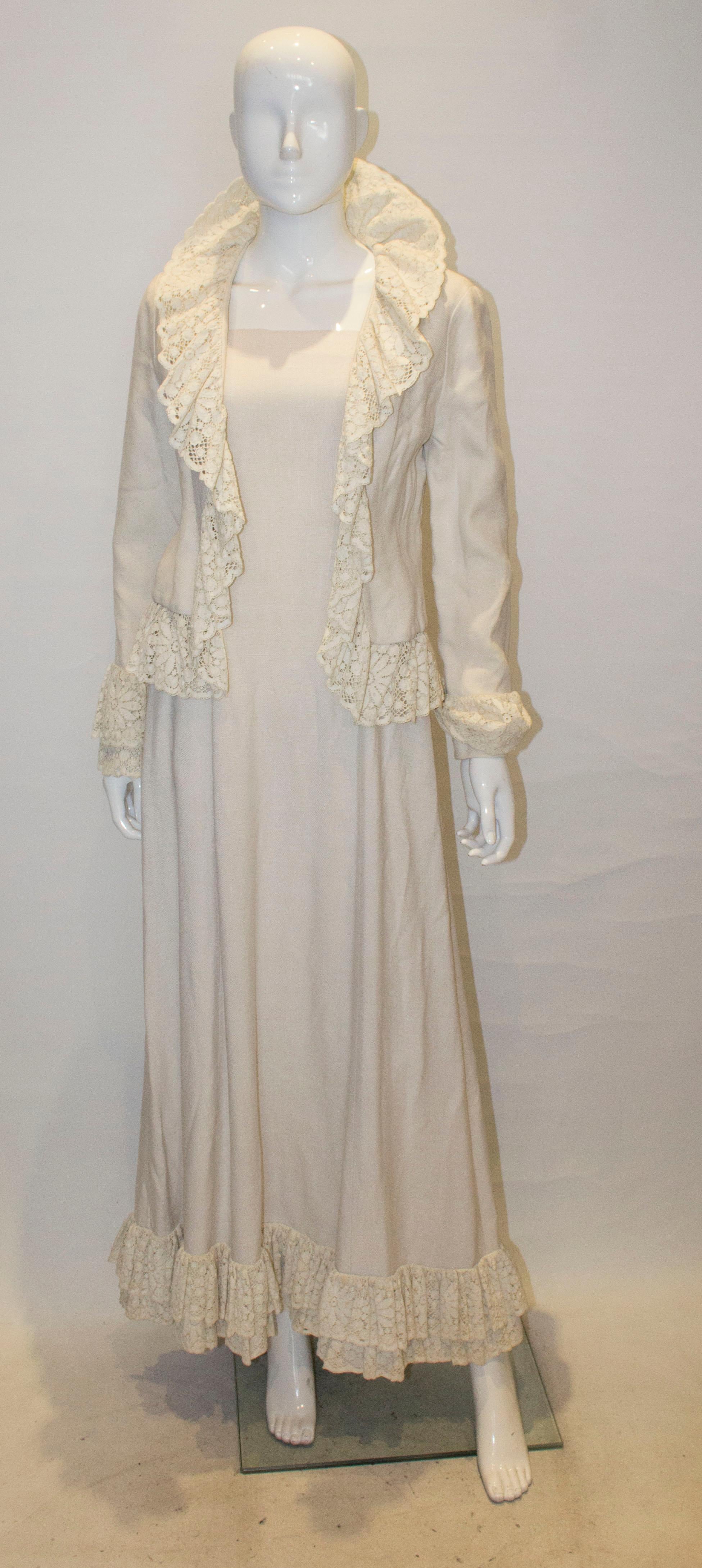 A long white linen vintage dress with matching jacket by Jean Allen. The dress is in a heavy linen with a square neckline and double row lace frill at the hem. The jacket has frill detail on the neckline and cuffs. Both are fully
