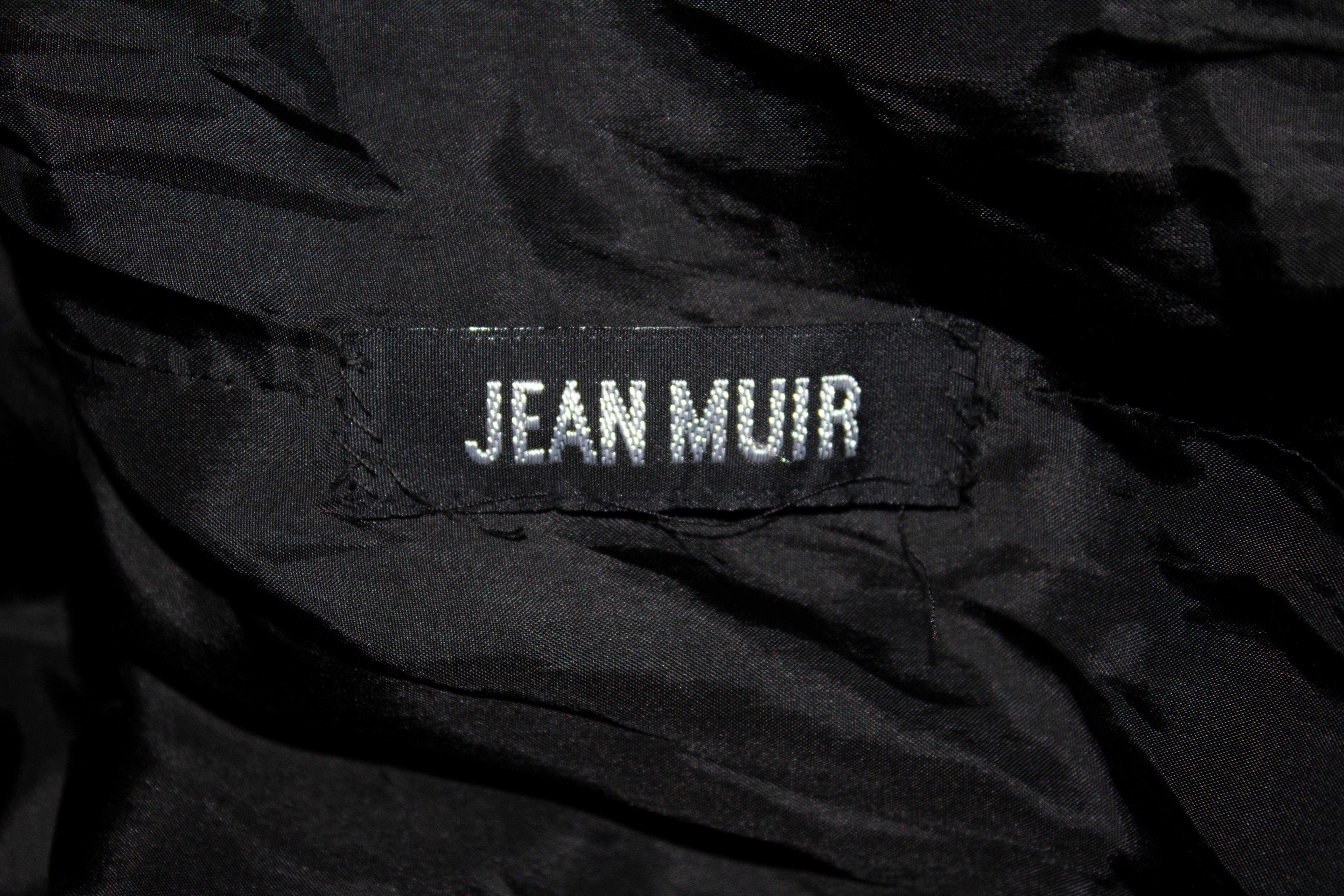 Una cargante chaqueta vintage de ante de Jean Muir ( línea principal), ideal para Primavera/Verano.
En un ante negro supersuave, la chaqueta tiene un ribete decorativo en el cuello y los puños, abertura delantera con botones, abertura de 5'' en la