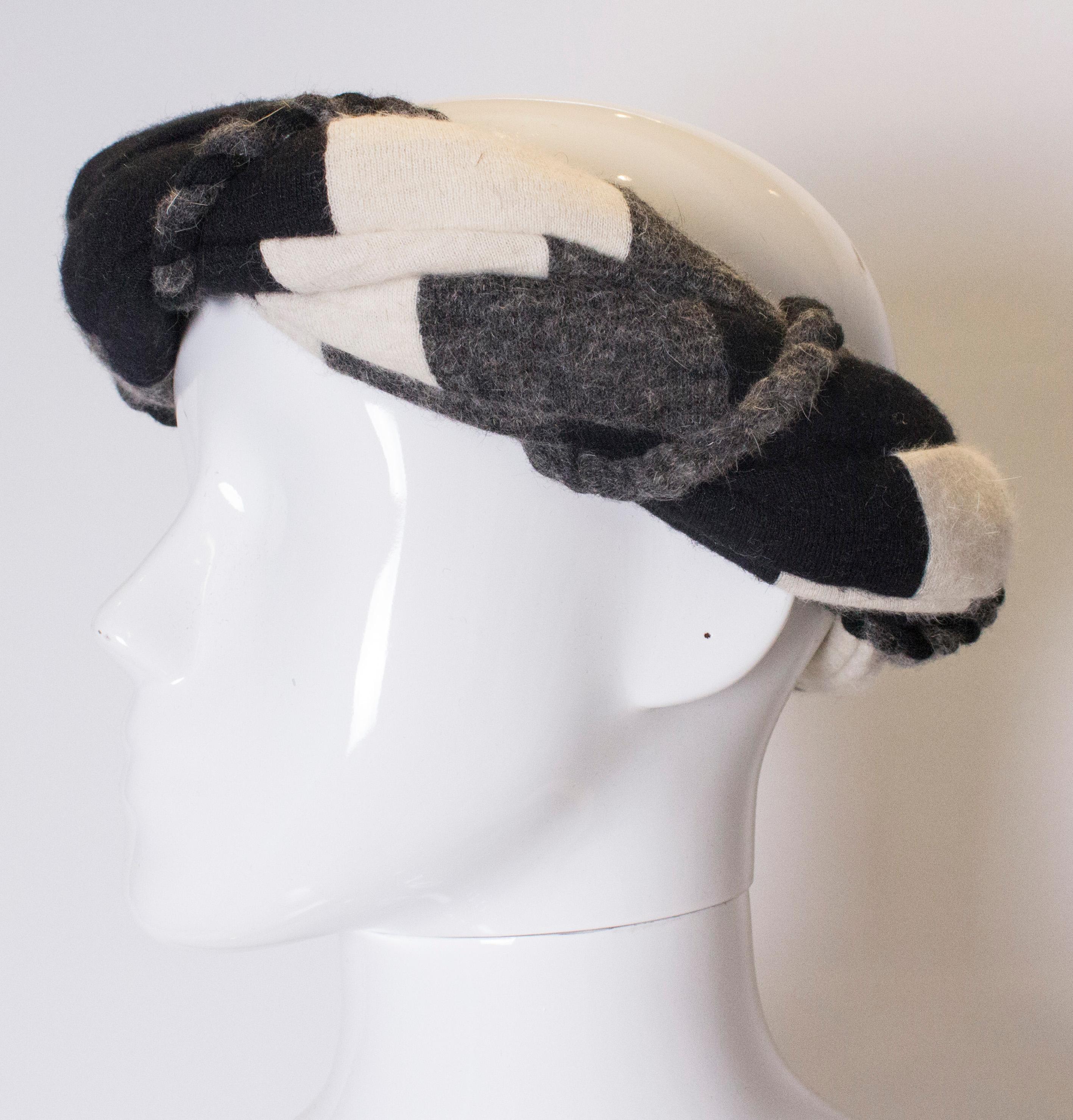 A chic vintage headband by Jean Muir. In shade of grey, black and white with a thin black and grey plait running across.