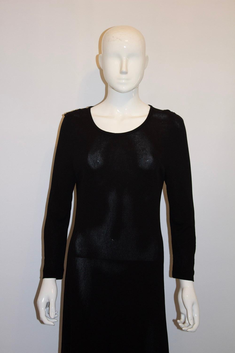 Un elegante vestitino nero vintage di Jean Muir, mainline. L'abito è in viscosa di ottima qualità e ha uno scollo rotondo,  e maniche a gomito. È sfoderato e ha uno spacco di 5'' su entrambi i lati.  Taglia 10 UK. Misure Seno fino a 34'', lunghezza