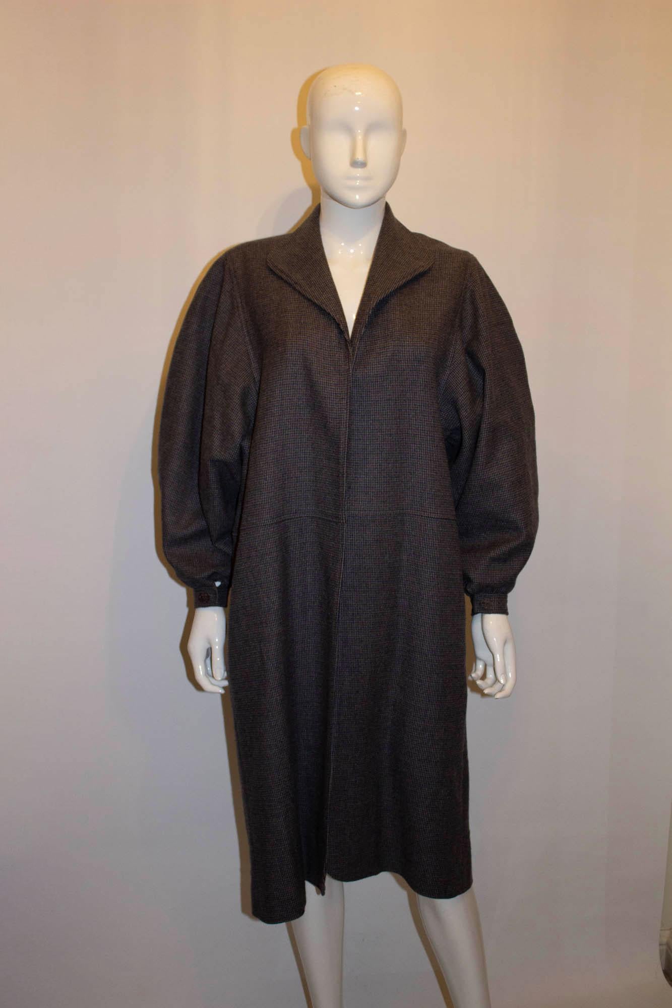 A fun vintage check wool coat by Jean Muir, main line.  The coat is in a blue ,brown and grey check, and is unlined. The coat has a single button cuff and a pocket on either side. 
UK size 10 , measurements; bust up to 42'', length 43''