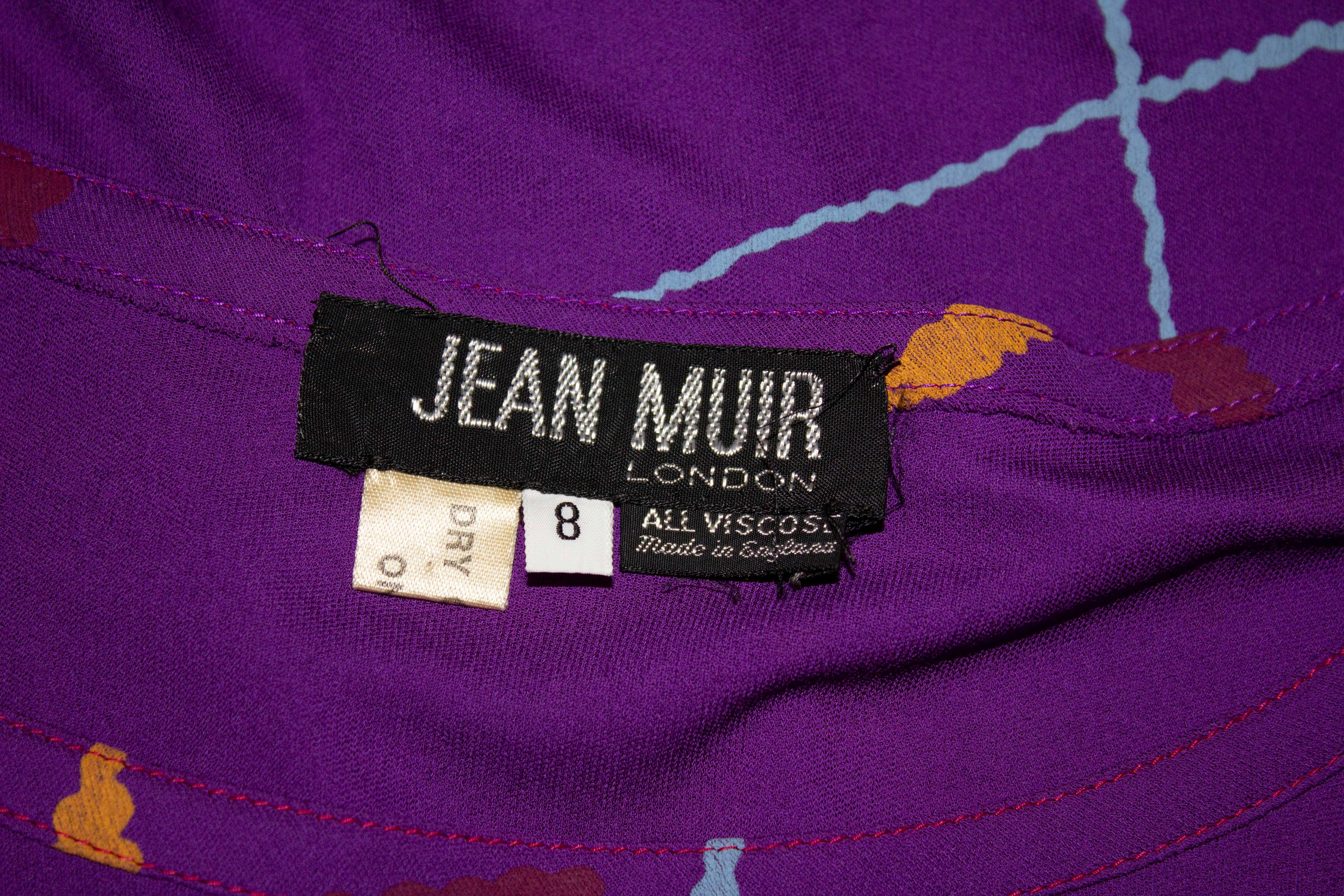 A colourful vintage top by Jean Muir ( main line), The top has a round neckline, pintucks on the the shoulder and short sleaves. The top has a purple background , with grey , blue , red and orange print.  Size 8 , viscose. Measurements: Bust up to