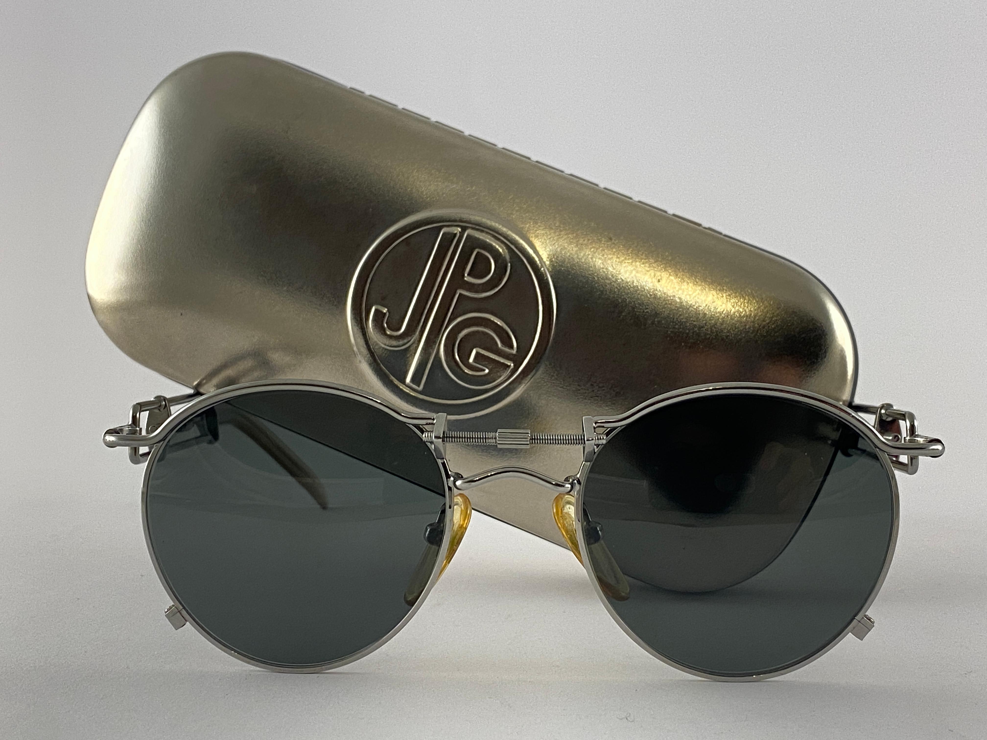 Vintage Jean Paul Gaultier 56 0174 Silber Details Rahmen. 
Dunkelgraue Gläser vervollständigen einen tragbaren JPG-Look.

Erstaunliches Design mit starken, aber raffinierten Details.
Design und Herstellung um 1900.
Leichte lagerungsbedingte