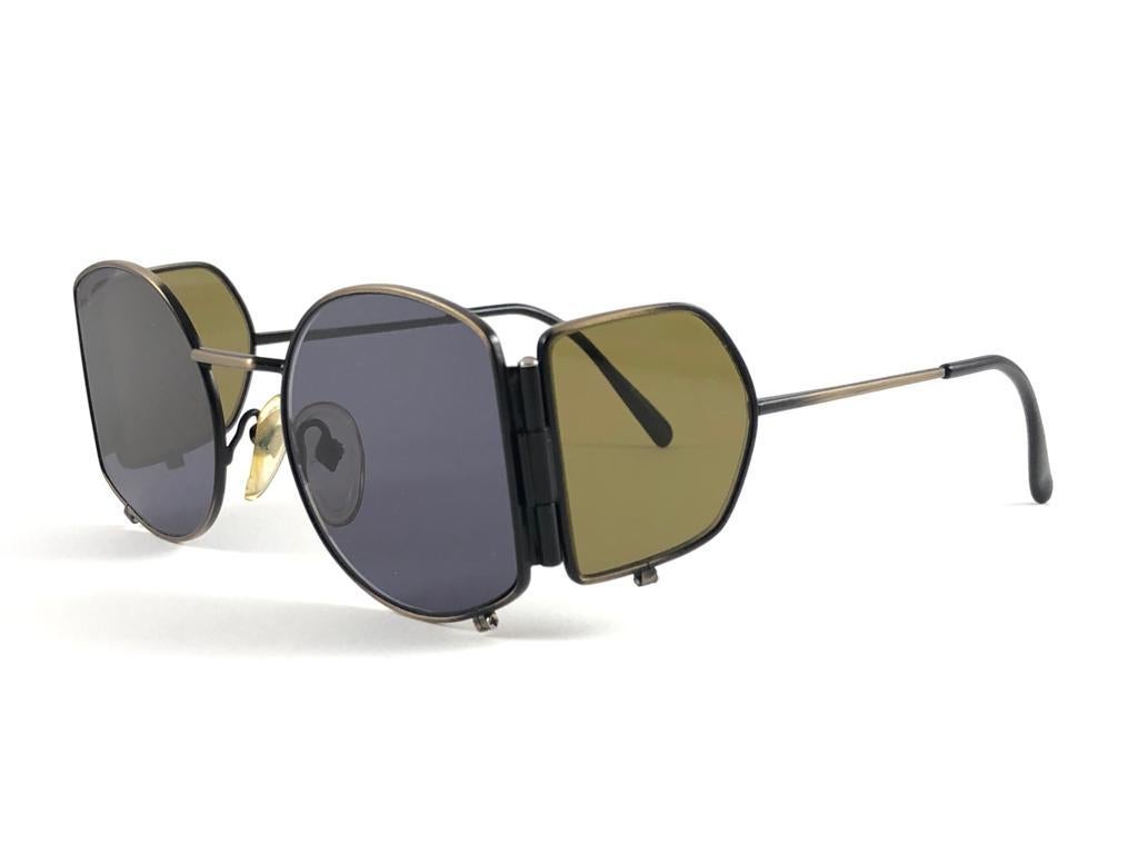 New Vintage Jean Paul Gaultier 56 9172 flat lenses with side cups detailed frame. 
Flat smoke grey lenses that complete a ready to wear JPG look. The lenses have minor sign of wear.

Amazing design with strong yet intricate details.
Design and