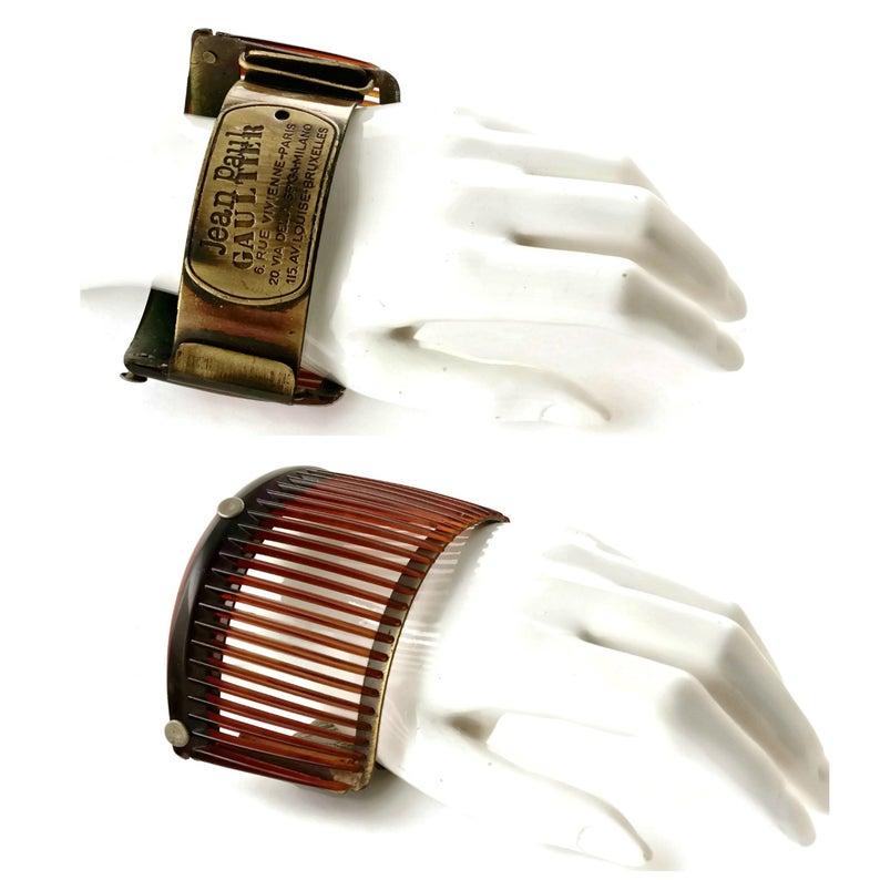 Vintage JEAN PAUL GAULTIER Address Comb Cage Cuff Bracelet

Measurements:
Height: 2 3/8 inches
Inside Circumference: 3 1/8 inches (7.93 cm) X 2 2/8 inches (5.71 cm)

Features:
- 100% Authentic JEAN PAUL GAULTIER.
- Rustic metal finish with engraved