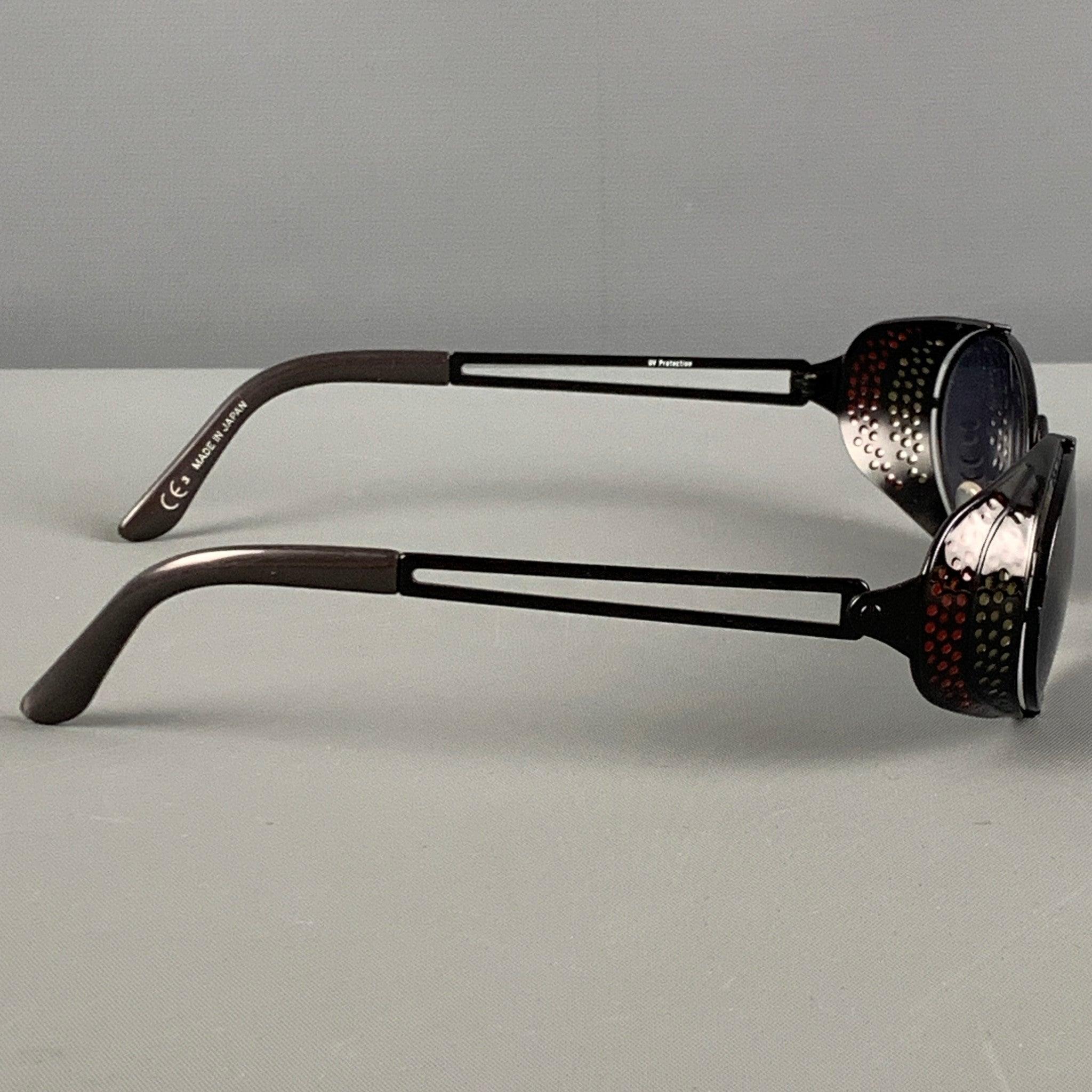 Vintage JEAN PAUL GAULTIER Sonnenbrille aus schwarzem und rotem Metall mit perforiertem Schilddesign, UV-Schutz und getönten Gläsern. Hergestellt in Japan.
Sehr gut
Gebrauchtes Zustand. 

Markiert:   7B  

Abmessungen: 
  Länge: 12 cm. Höhe: 3.5