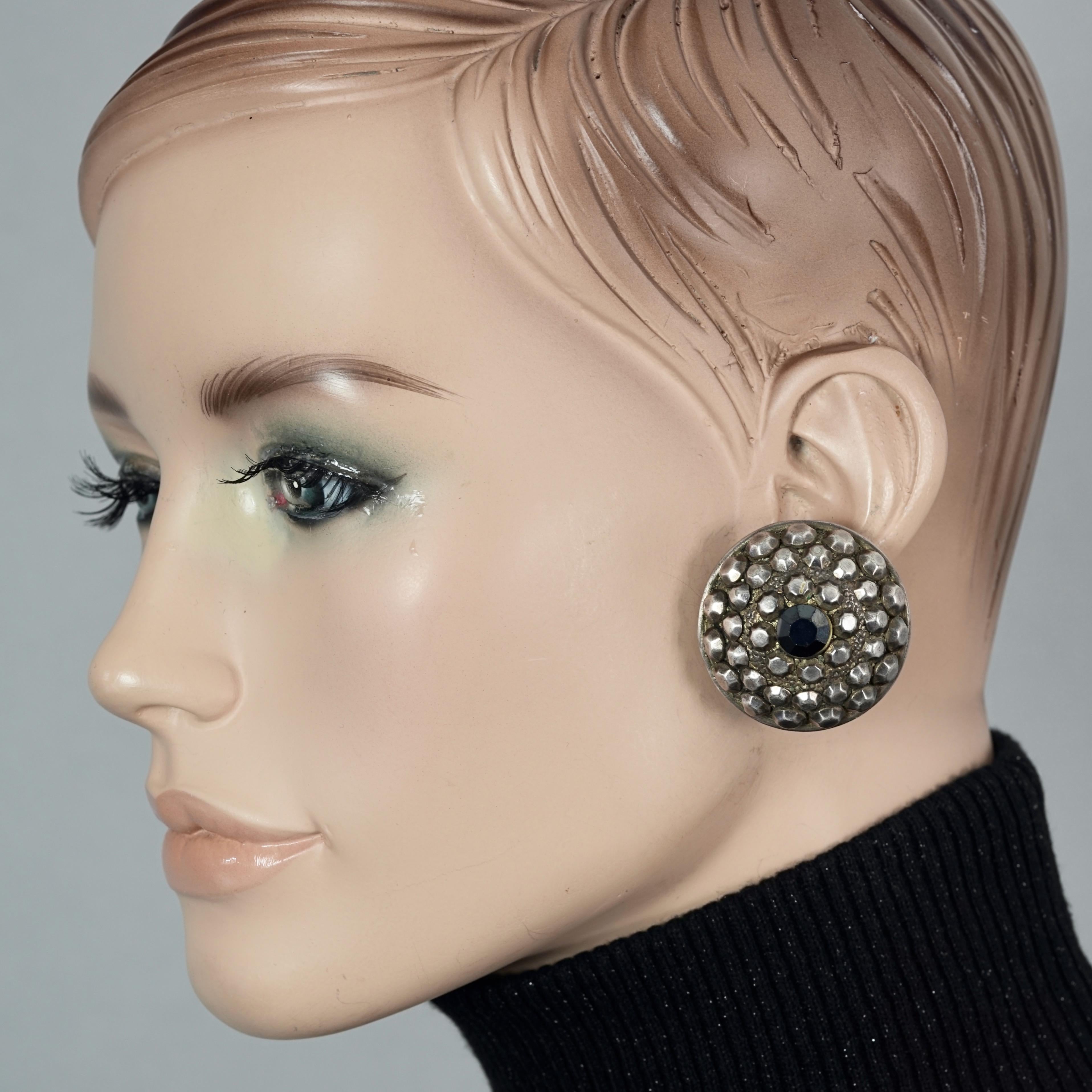 Vintage JEAN PAUL GAULTIER Ethnic Studded Disc Earrings

Measurements:
Height: 1.45 inches (3.7 cm)
Width: 1.45 inches (3.7 cm)
Depth: 0.75 inch (1.9 cm)
Weight per Earring: 16 grams

Features:
- 100% Authentic JEAN PAUL GAULTIER.
- Ethnic inspired