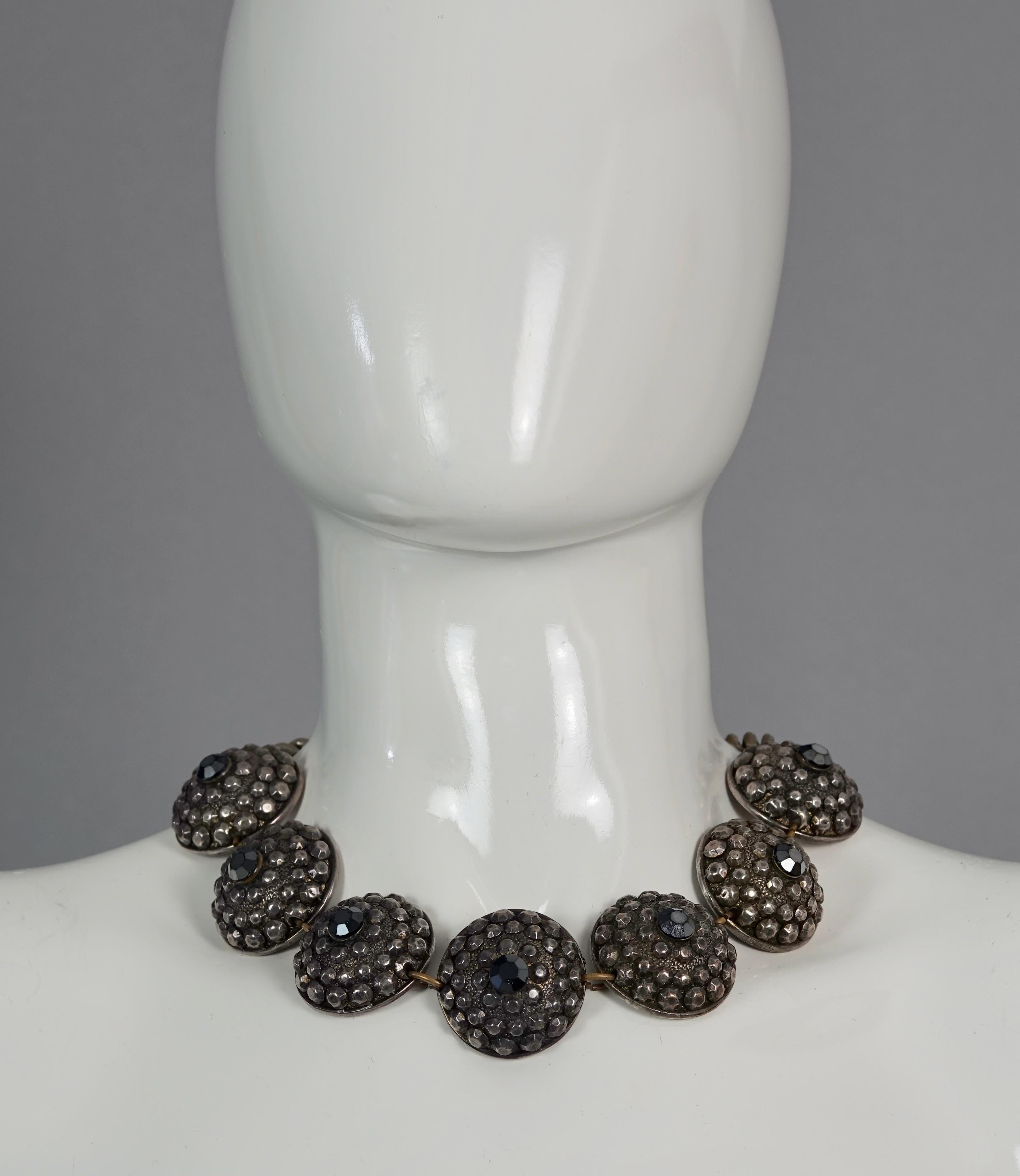 Vintage JEAN PAUL GAULTIER Ethnic Studded Disc Necklace

Measurements:
Height: 1.45 inches (3.7 cm)
Wearable Length: 18.11 inches (46 cm)

Features:
- 100% Authentic JEAN PAUL GAULTIER.
- Ethnic inspired disc link necklace with studs and black