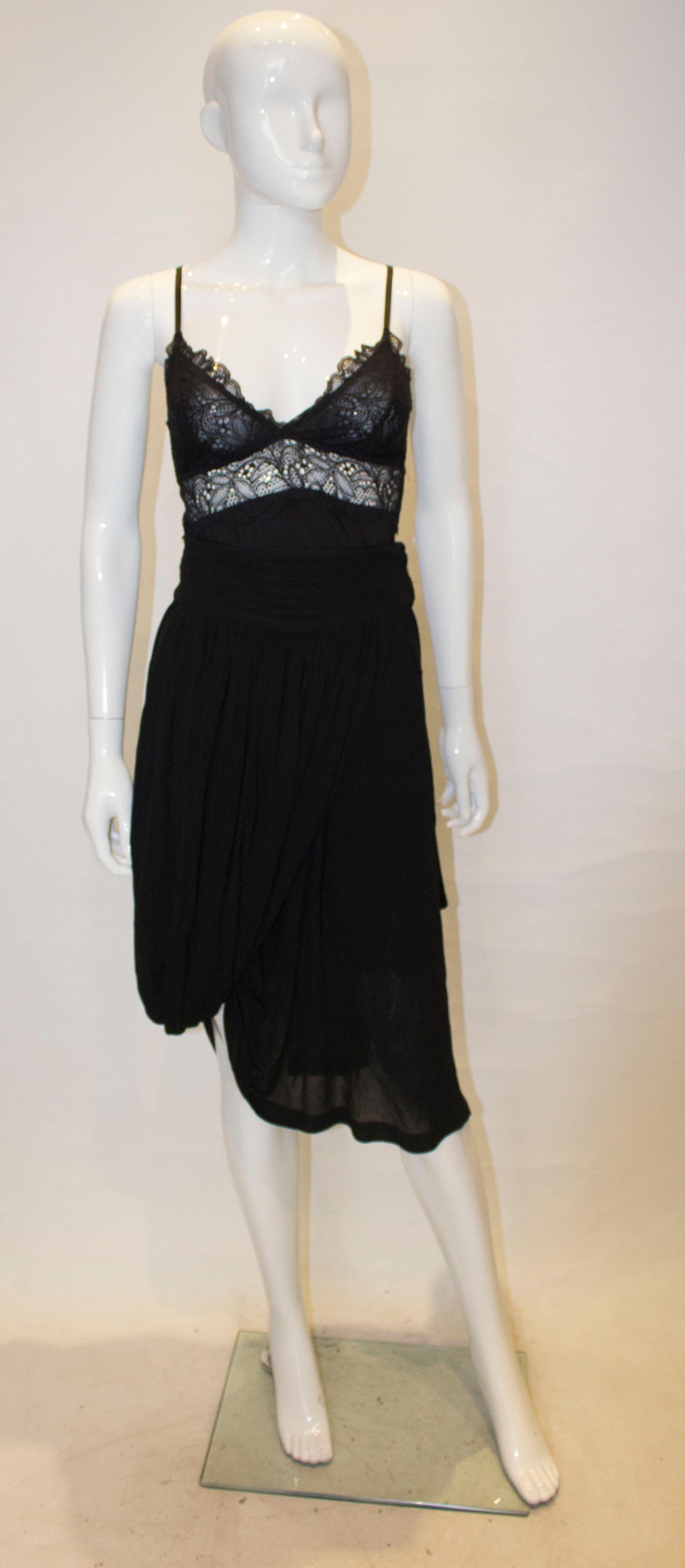 A fun black skirt by Jean Paul Gaultier, Femme line.  The skirt has a wide waistband with popper fastening, and a fold of fabric over one side.