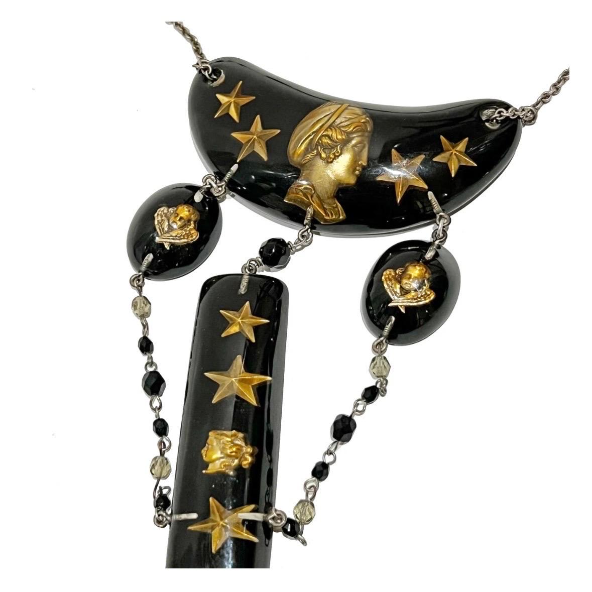 Vintage Lucite Tiered necklace by Jean Paul Gaultier
Circa 1995
Made in France
Matte silver metal hardware 
Black lucite shapes with gold cameo and stars beneath clear resin layer connected by black and grey beaded chain
Adjustable length 
Lobster