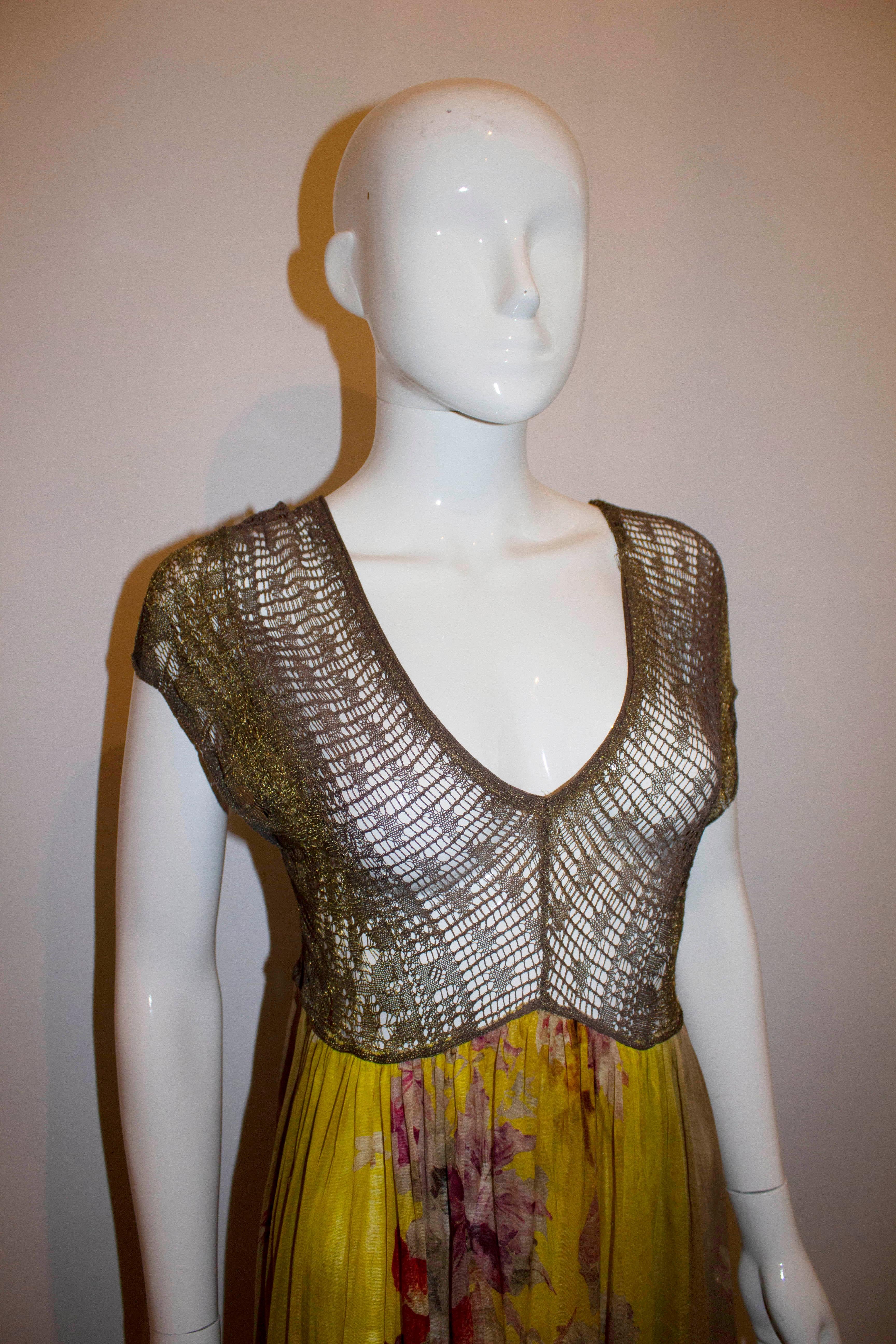 A fabulous vintage dress by Jean Paul Gaultier Maille Femme line. The dress has a gold and brown weave bodice , with a v neckline and back line. The lower part has a yellow background with grape and flower print. 
Size S Bust 36'', length 47''