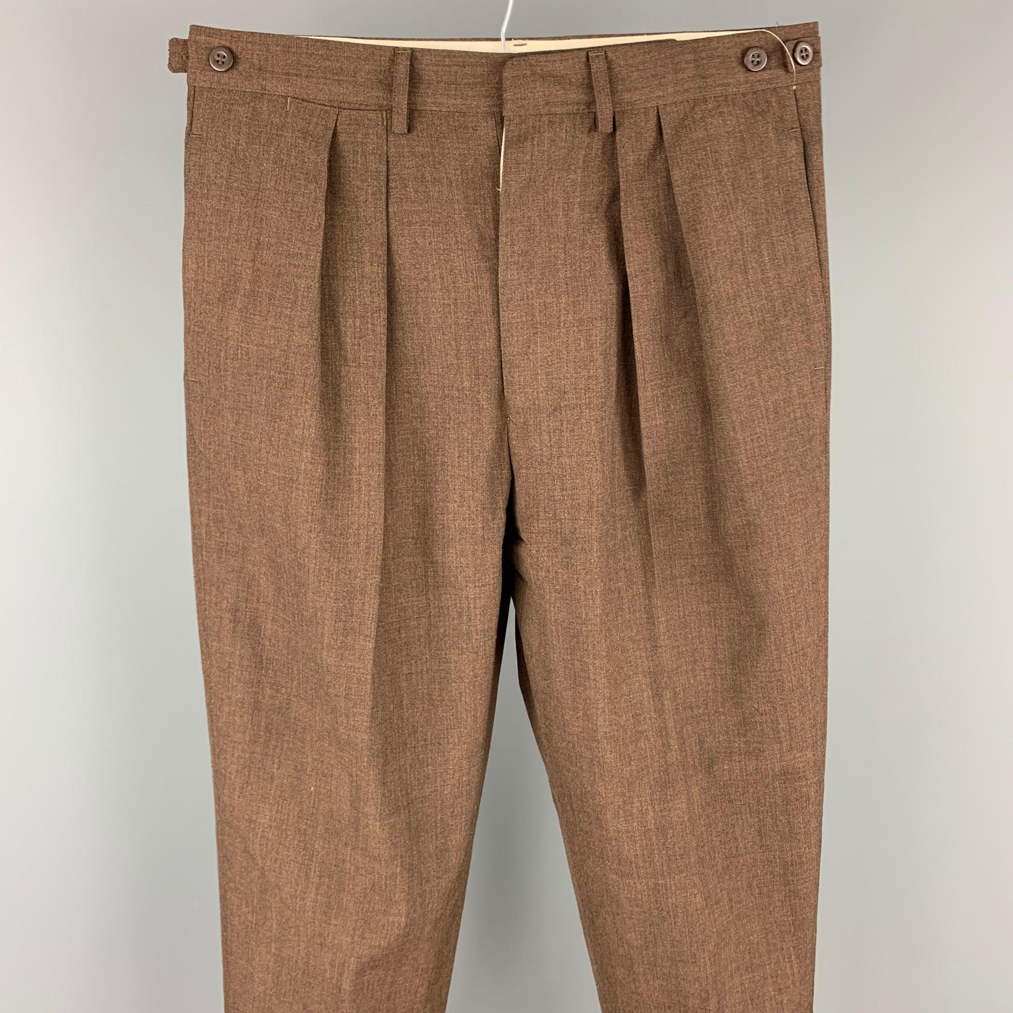 Vintage JEAN PAUL GAULTIER dress pants comes in a brow wool blend featuring a pleated style, side tabs, front tab, and a button fly closure. Made in Italy.

Good Pre-Owned Condition.
Marked: IT 50

Measurements:

Waist: 32 in.
Rise: 13 in.
Inseam: