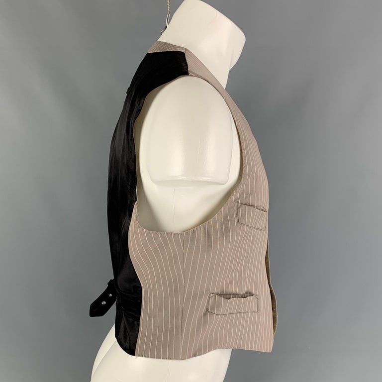 Vintage JEAN PAUL GAULTIER vest comes in a taupe & white stripe material featuring a back black panel, back belt, front pockets, and a buttoned closure. 

Very Good Pre-Owned Condition. Light discoloration at neckline.
Marked: