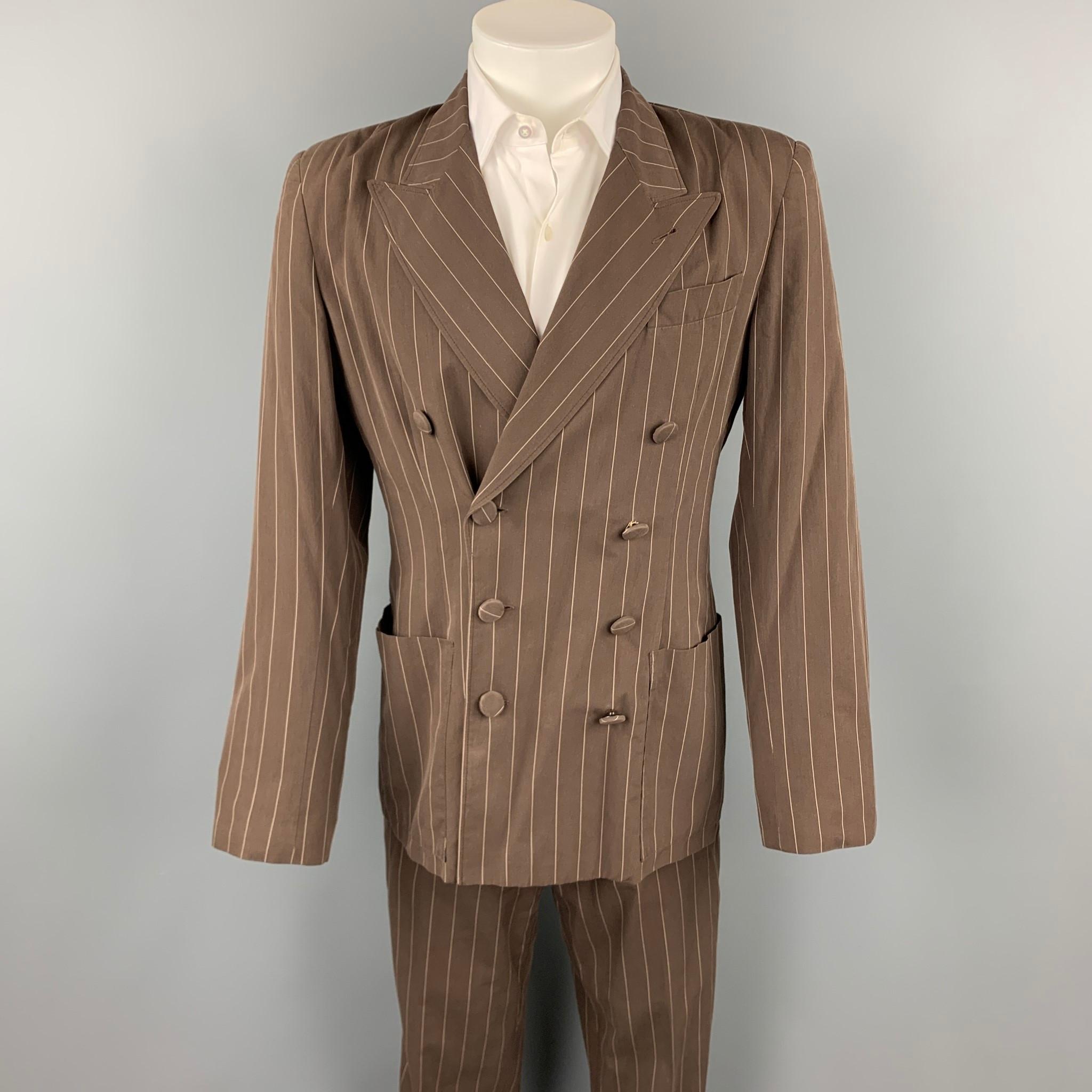 Vintage JEAN PAUL GAULTIER suit comes in a brown stripe cotton with a full mesh liner and includes a double breasted sport coat with a peak lapel and matching flat front trousers. Made in Italy.

Good Pre-Owned Condition.
Marked: