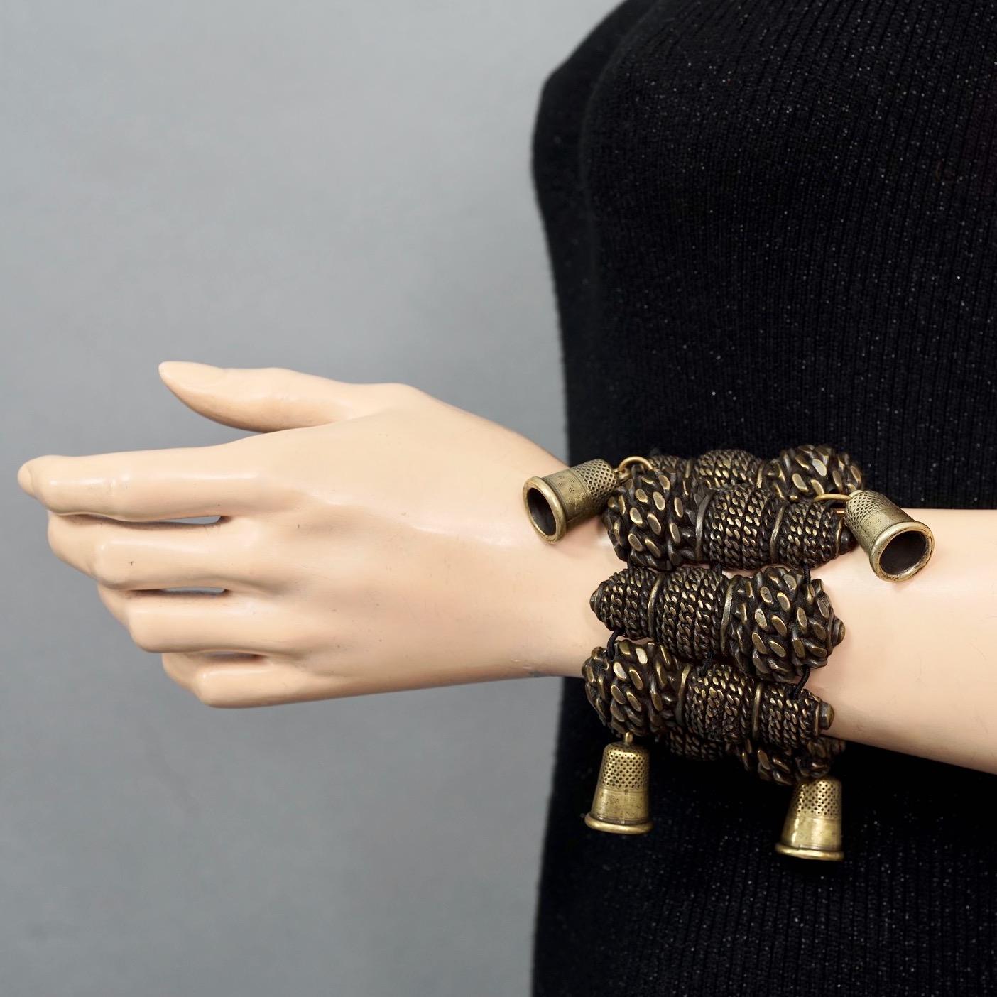 Vintage JEAN PAUL GAULTIER Thimble Brutalist Cuff Bracelet

Measurements:
Height: 2.55 inches (6.5 cm)
Wearable Length: 6.10 inches (15.5 cm) without stretching the elastic

Features:
- 100% Authentic JEAN PAUL GAULTIER.
- Brutalist gilt rope twist