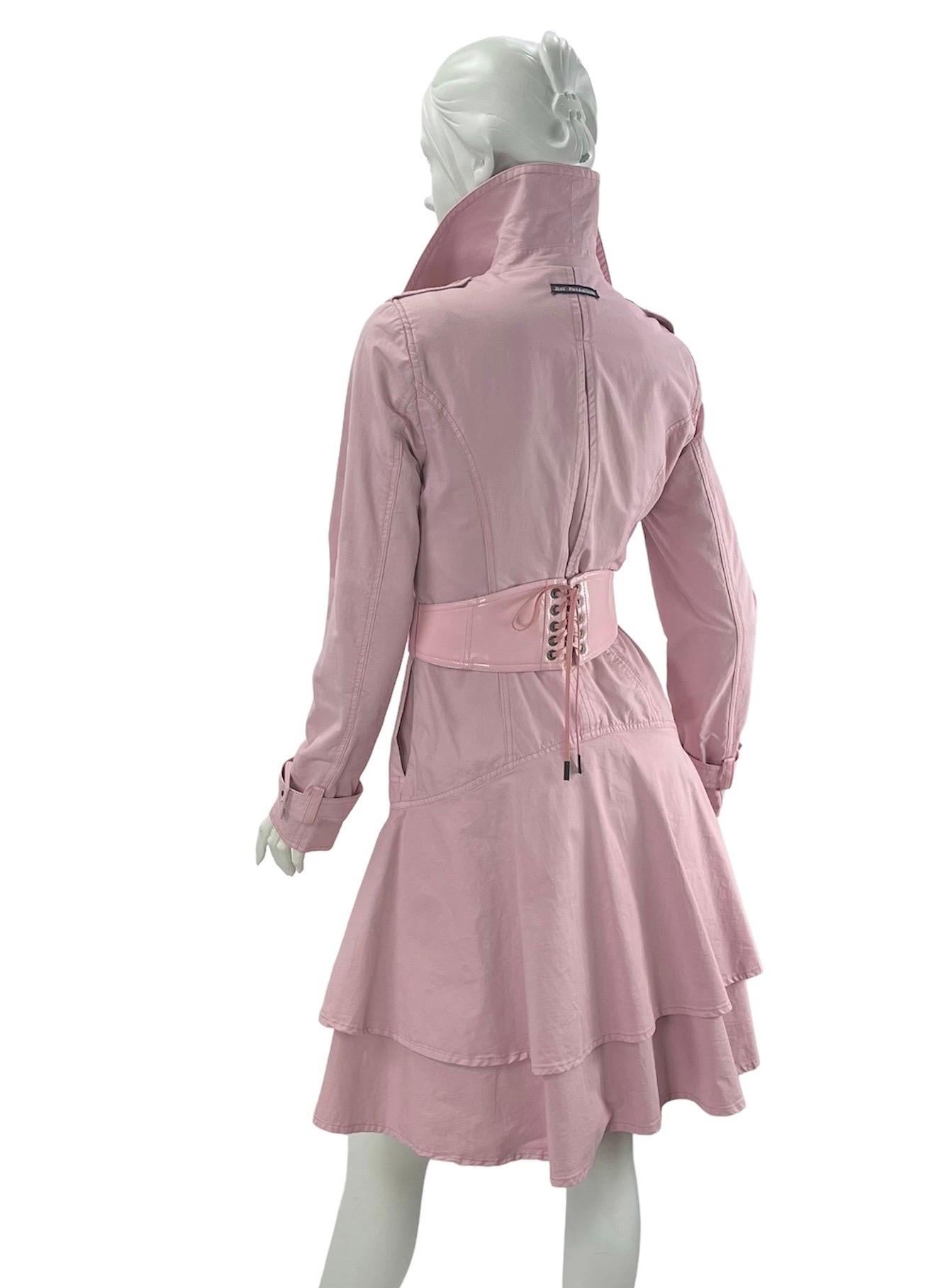 Vintage Jean Paul Gaultier Tiered Ruffle Trench Coat with Patent Leather Corset Belt
Italian Size - 40 
Powder Pink, Double breasted, Signature buttons, Signature Grommets, Two side pockets, Removable corset belt, Adjustable buckle cuffs, Semi