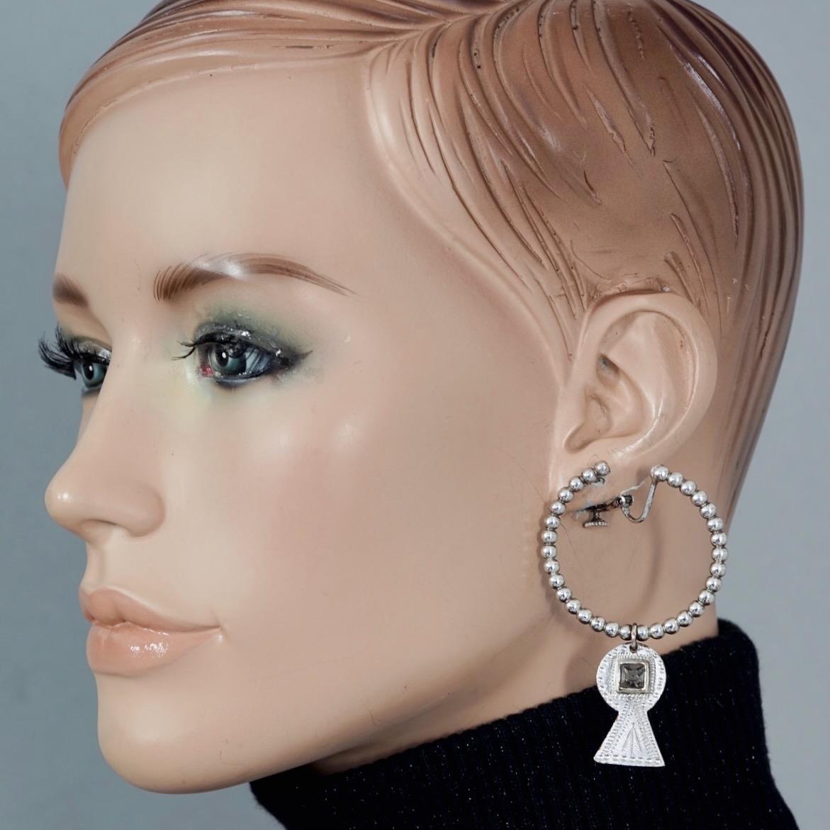 Vintage JEAN PAUL GAULTIER Tribal Creole Charm Silver Dangling Earrings

Measurements:
Height: 2.76 inches (7 cms)
Diameter: 1.65 inches (4.2 cms)
Weight per Earring: 14 grams

Features:
- 100% Authentic JEAN PAUL GAULTIER.
- Creole earrings in