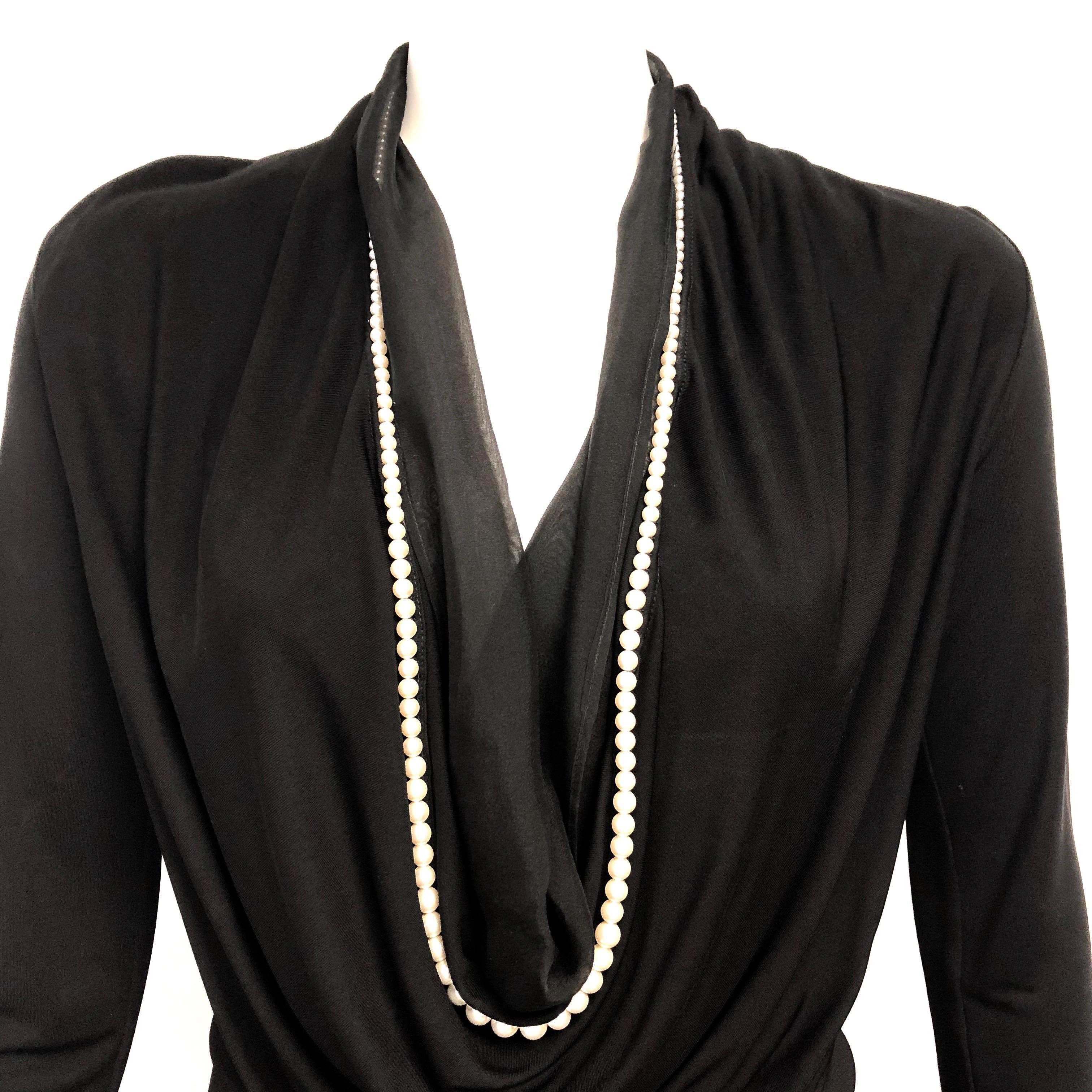 Vintage Jean Paul Gaultier black jersey plunging neckline dress with attached white pearl strand collar. The dress has a sheer silk chiffon lining around the neckline cleavage. Classy and timeless.   
Size: 6 US / 8 GB / 40 I / 36 F / 36
