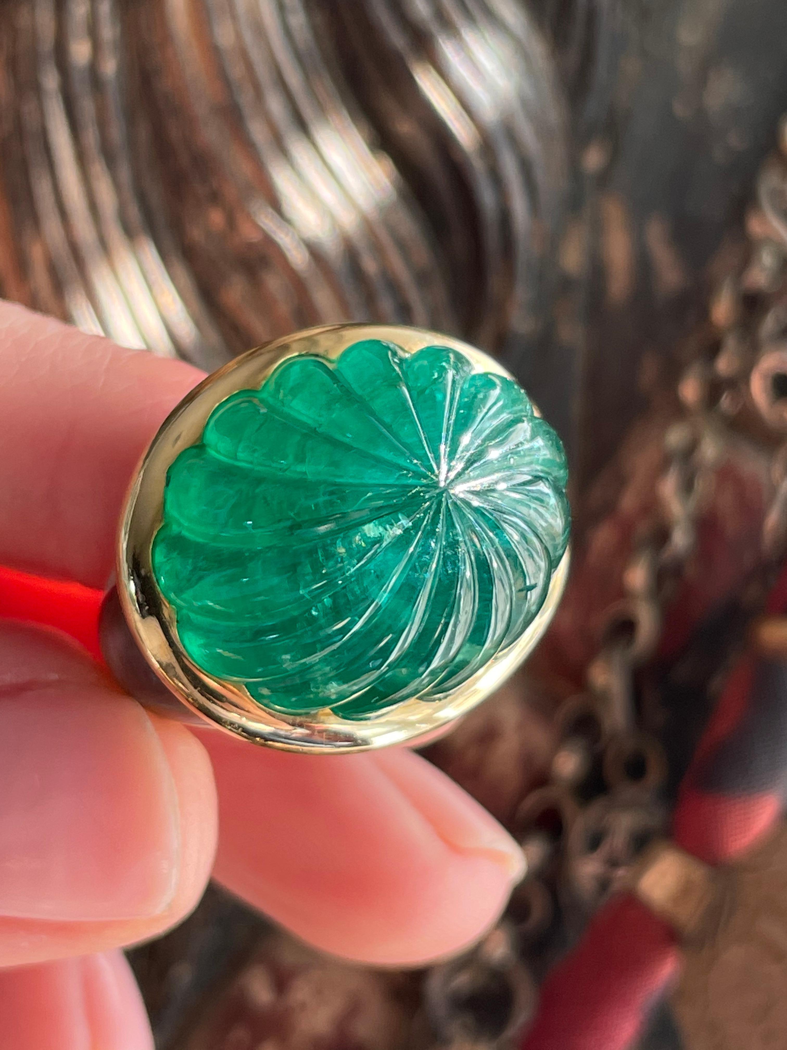 This stunning and substantial late 20th century ring was masterfully fabricated by Jean-Pierre Brun. An estimated 35 carat fluted emerald cabochon is bezel-set in gleaming 18k gold and framed by inlaid mother of pearl shoulders that smoothly
