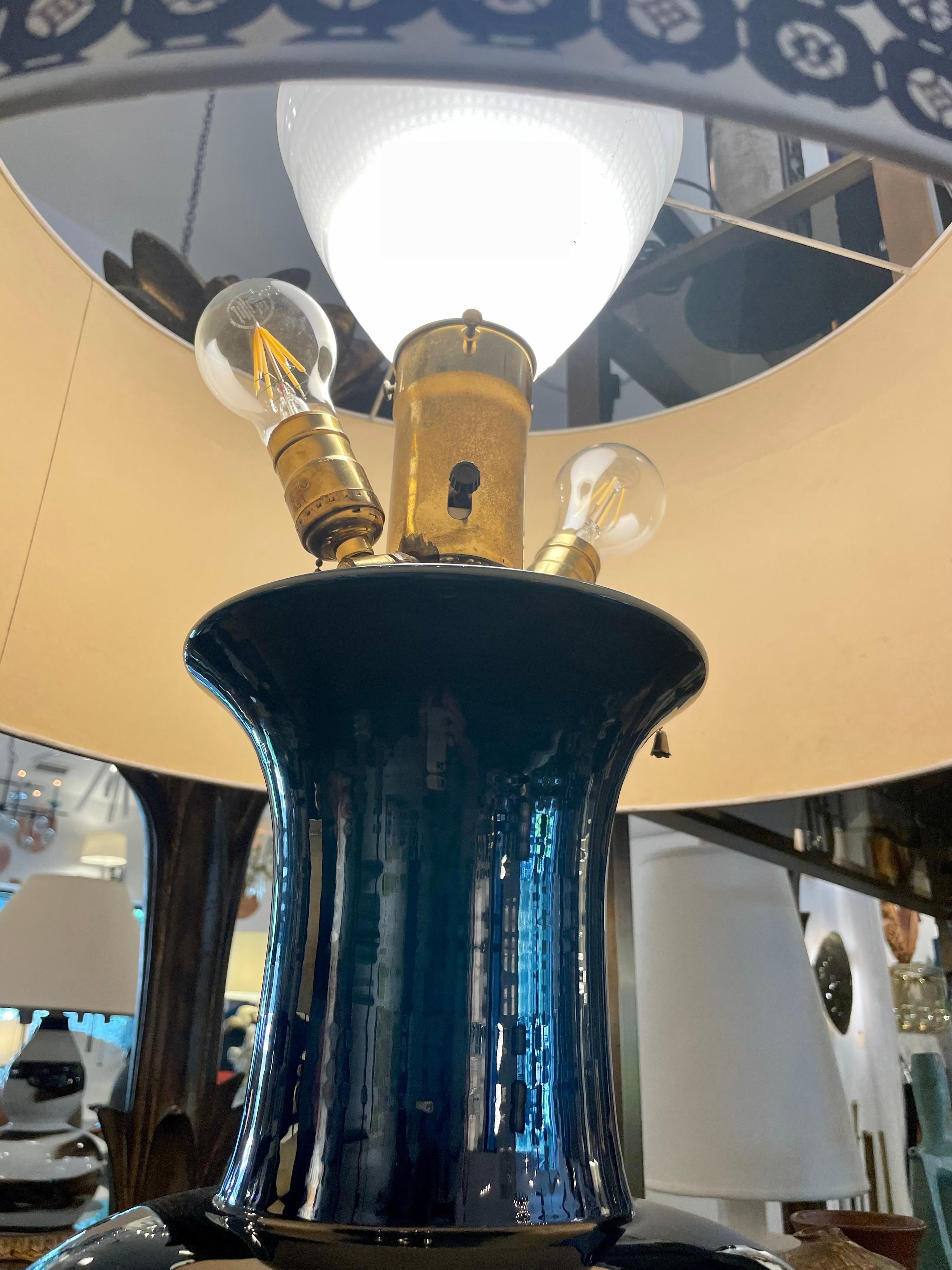 This is an extraordinary oversized glazed ceramic table lamp with 3 light sockets, one facing up with original milk glass diffuser, the other two arms with Edison base sockets, providing wonderful light source. Tag signature to base and this custom