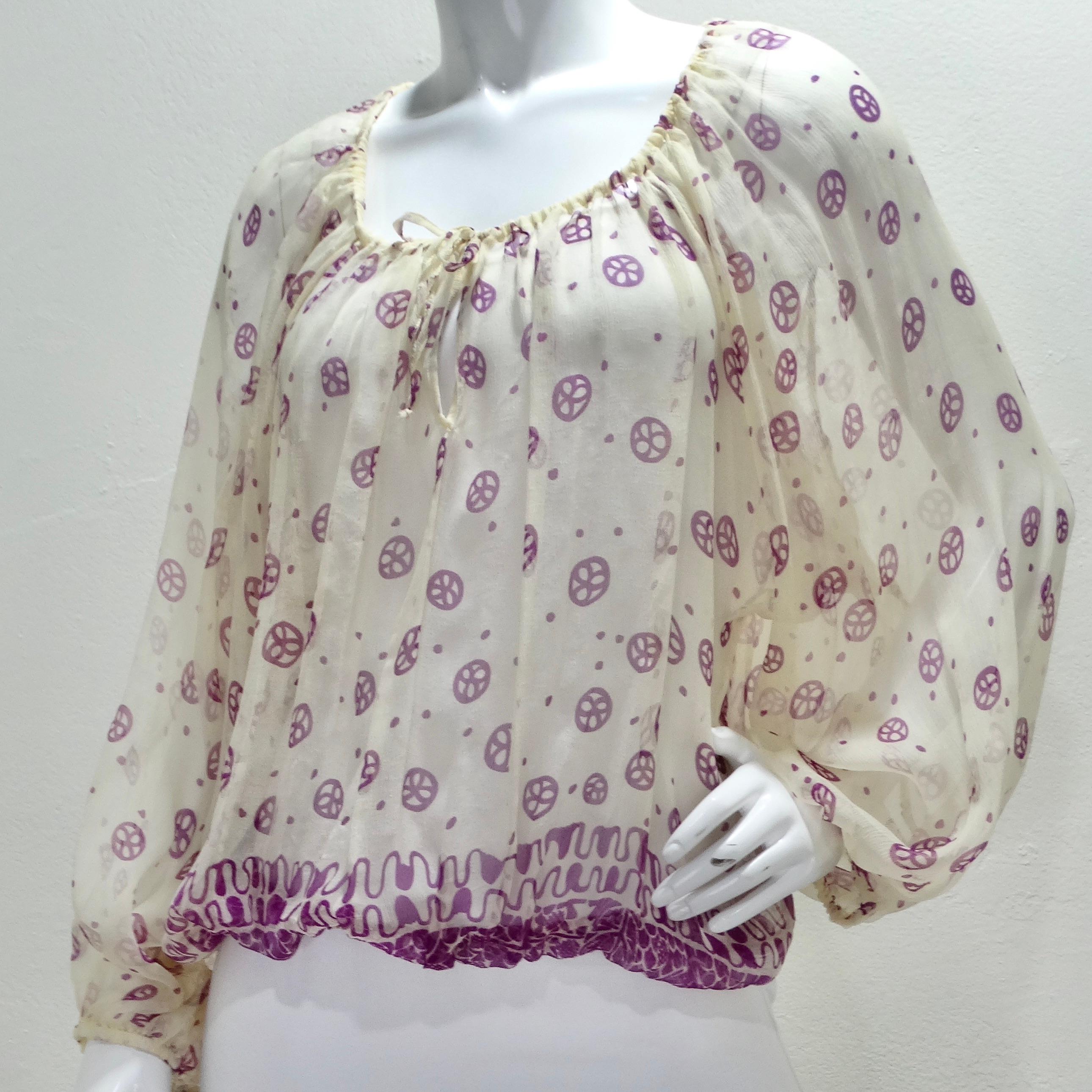 Indulge in vintage luxury with this exquisite Vintage Jean Paul Gaultier Purple Print Blouse. This billowing, long-sleeved blouse is a masterpiece of fashion design. Crafted from a lightweight, sheer ivory fabric adorned with captivating purple