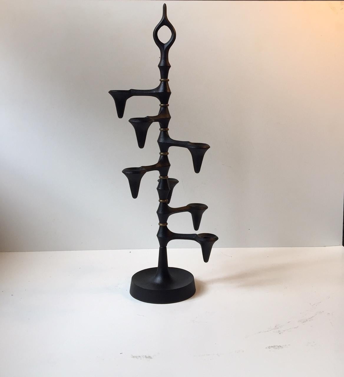 Large sculptural candleholder designed by Jens Harald Quistgaard. Manufactured by IHQ Danish Design in the 1960s in Denmark. Made of black lacquered cast iron and features seven rotating/adjustable holders for candles separated by brass rings. The
