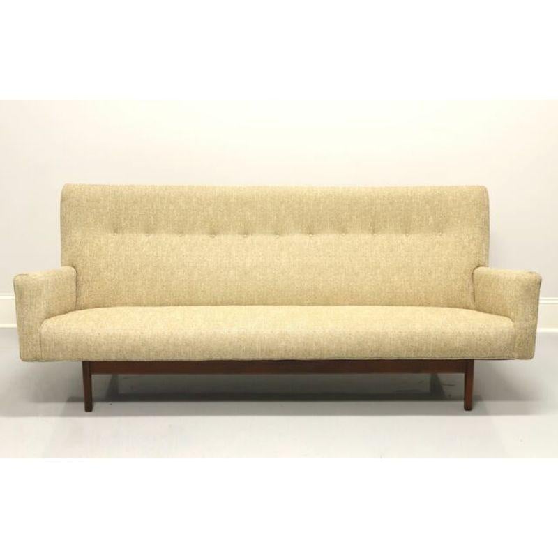 A Mid 20th Century Danish Modern floating three seat sofa by Jens Risom, his U150 model. Features a walnut frame, high back with a button tufted row, a neutral tweed like fabric and tapered legs. Made in the USA, circa 1950's. Model #: