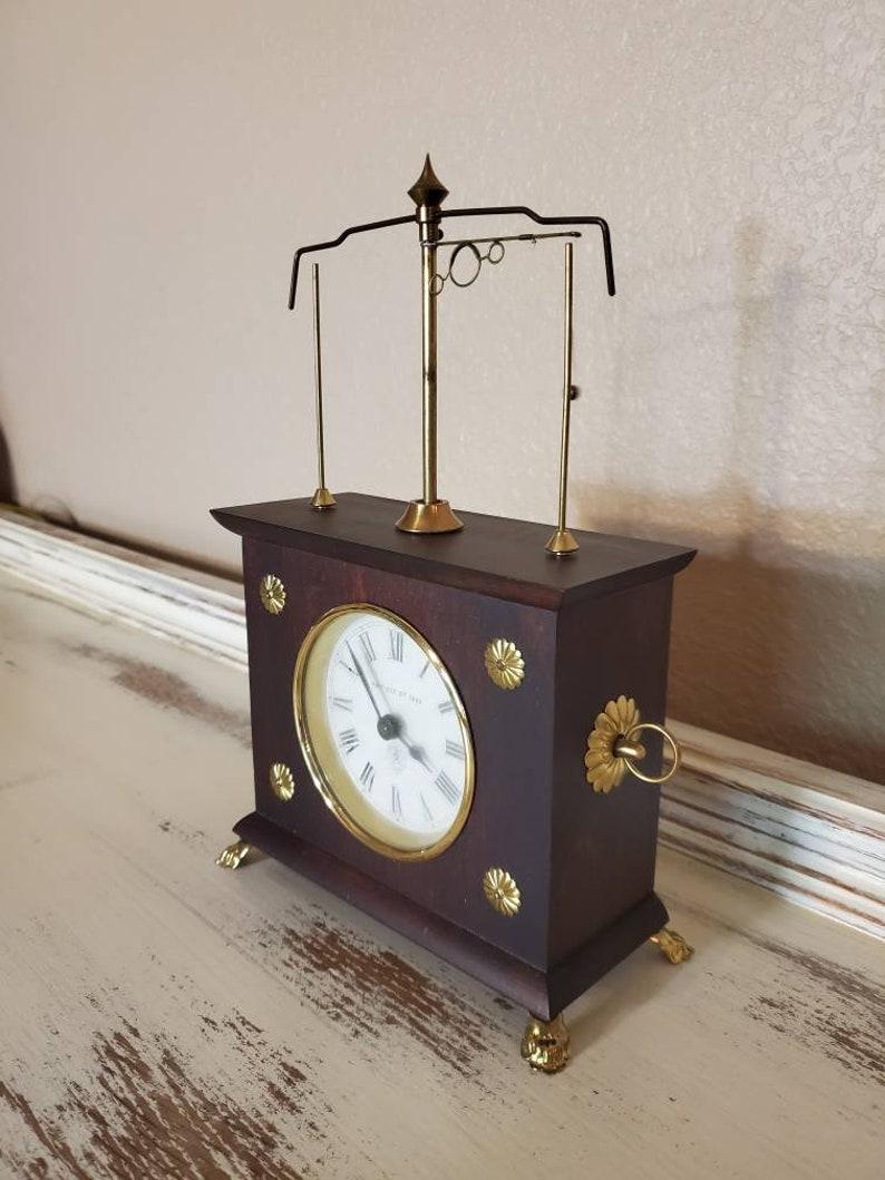 Beautiful and fascinating to watch run, a magnificent Jerome & Co. Horolovar flying ball pendulum novelty clock, in original box, having a flying pendulum over the case, with beautiful mahogany finish, white dial with roman numerals, rising on gilt