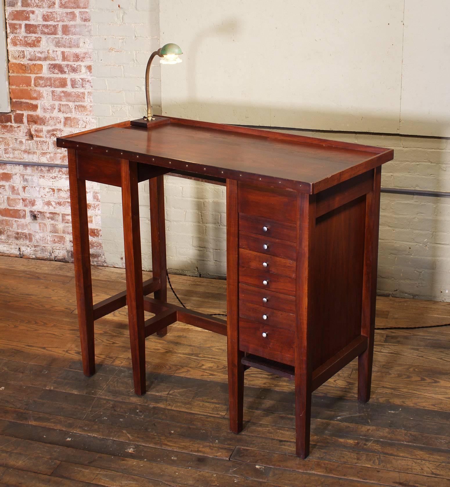 Vintage industrial jewelers work table, workbench with desk light. Features seven drawers, a split level top, two small storage cubby holes, one under the top center, and one under the drawers. Bench measures 45 5/8