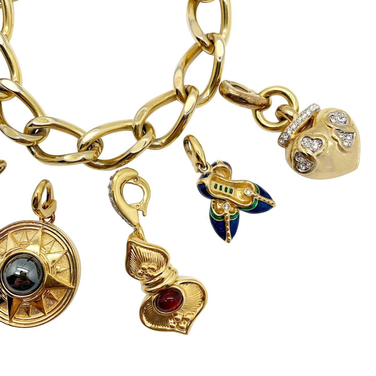 A wonderfully whimsical statement vintage detachable charm bracelet. Featuring an array of lustrous and symbolic charms along a flattened curb bracelet. The looks you can create feel endless. Each charm is beautiful in it's own way.

Vintage