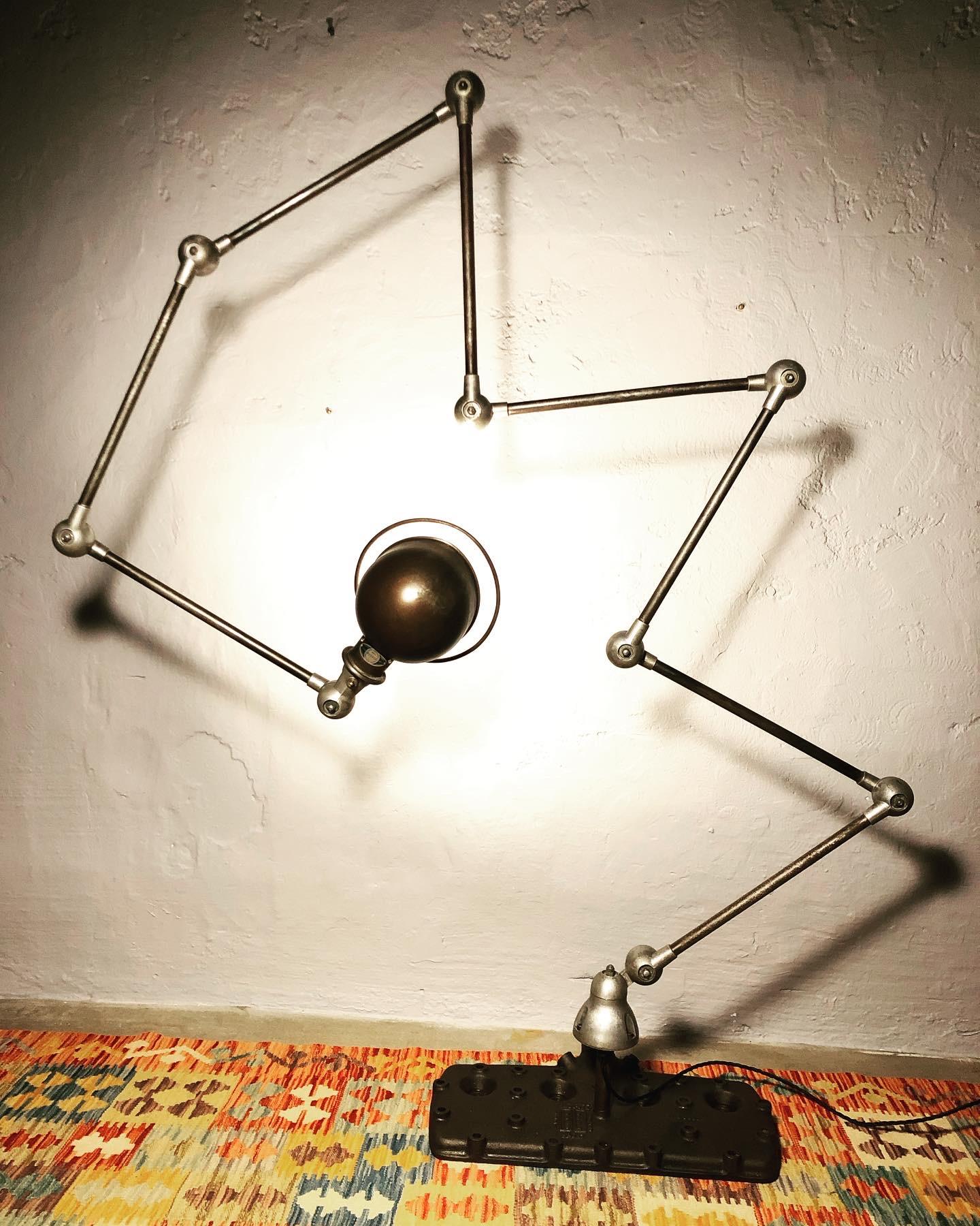 An iconic 8 arm mid century industrial work lamp by Jielde. 
This 8 arm industrial lamp is mounted onto a vintage V8 flathead. 
This is not just a lamp it is a work of art and incredibly sculptural.
The flathead is a perfect base for this lamp