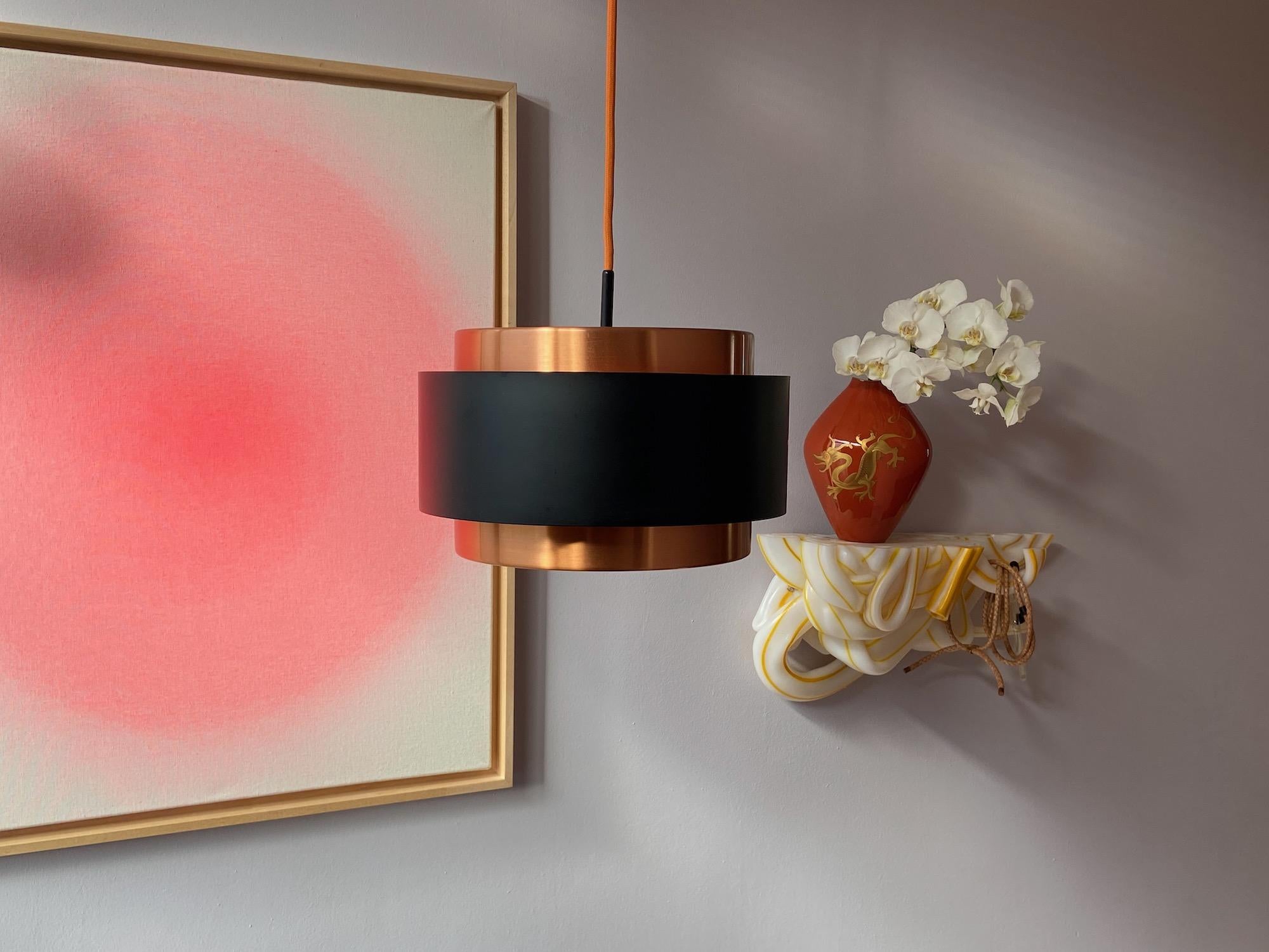 Jo Hammerborg Saturn pendant lamp for Fog & Mørup.
Copper metal, with black colored metal and acrylic top and button plate. New orange fabric cord. With 1x E26/27 Edision screw socket ready to use. Good condition with nice patina and perfect