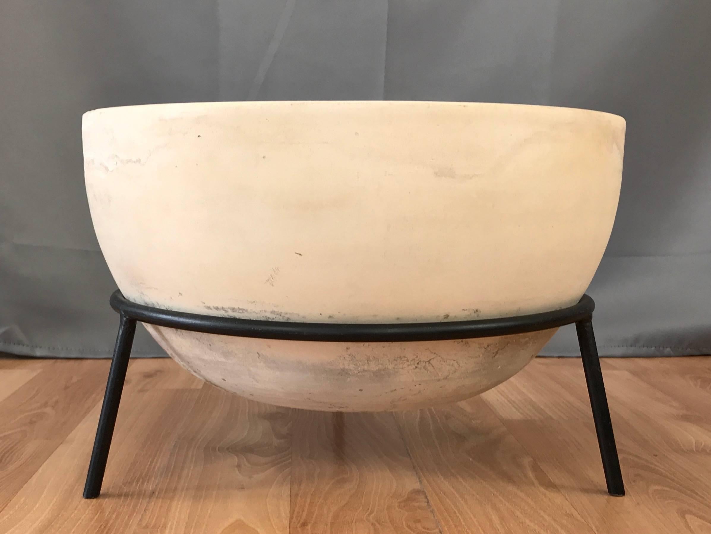 A rare 1950s FX planter with original MS-FX stand by John Follis for Architectural Pottery.

Large, slightly ovoid bowl-shaped ceramic vessel in cream with bisque finish. An assortment of naturally acquired spots and colorations on its lower portion