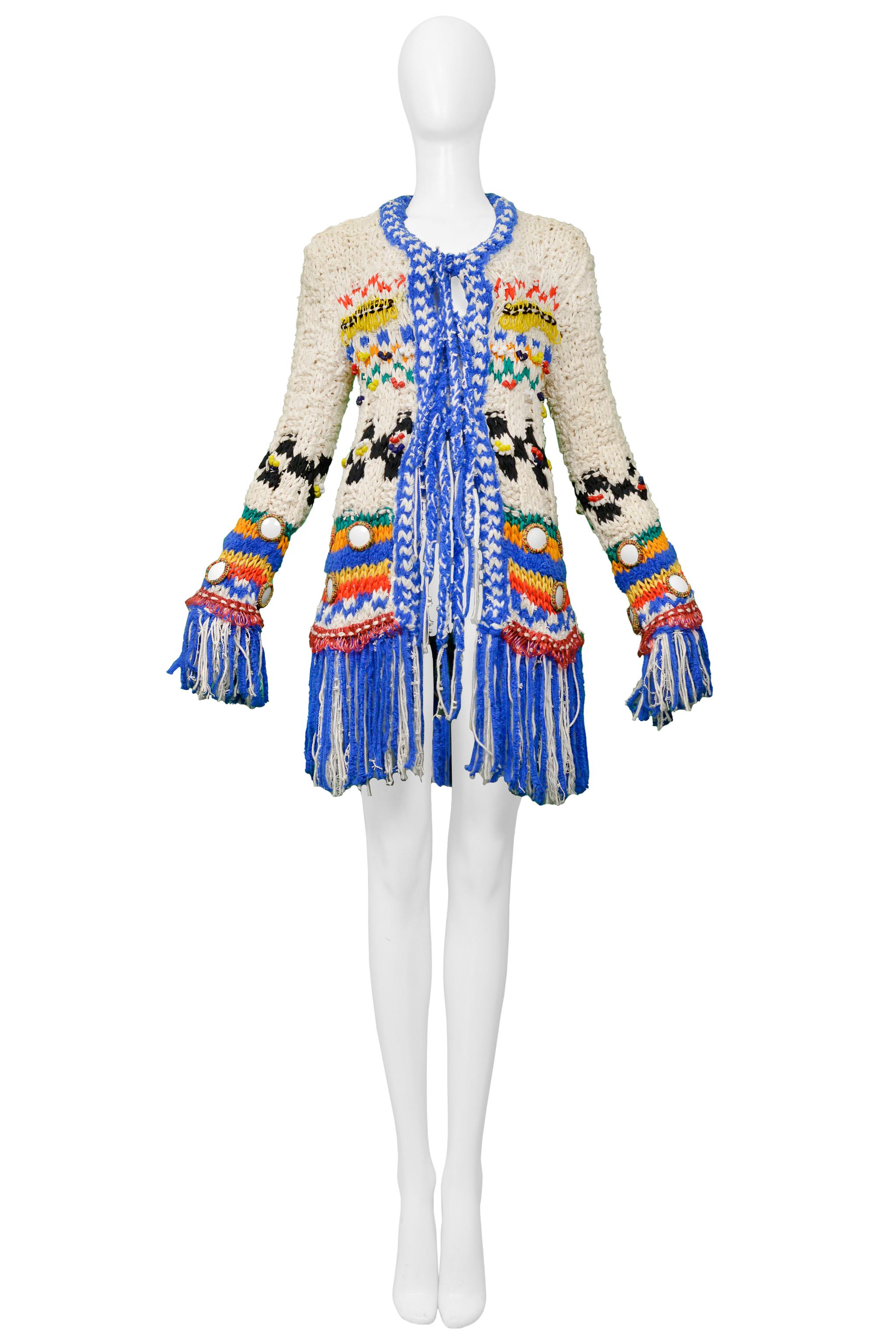 Resurrection Vintage is excited to offer a vintage John Galliano cream check & stripe knit sweater featuring colorful multi fabric woven accents and mirror details throughout, bead and plastic appliqués, tie front closure, and fringe hem and trim.