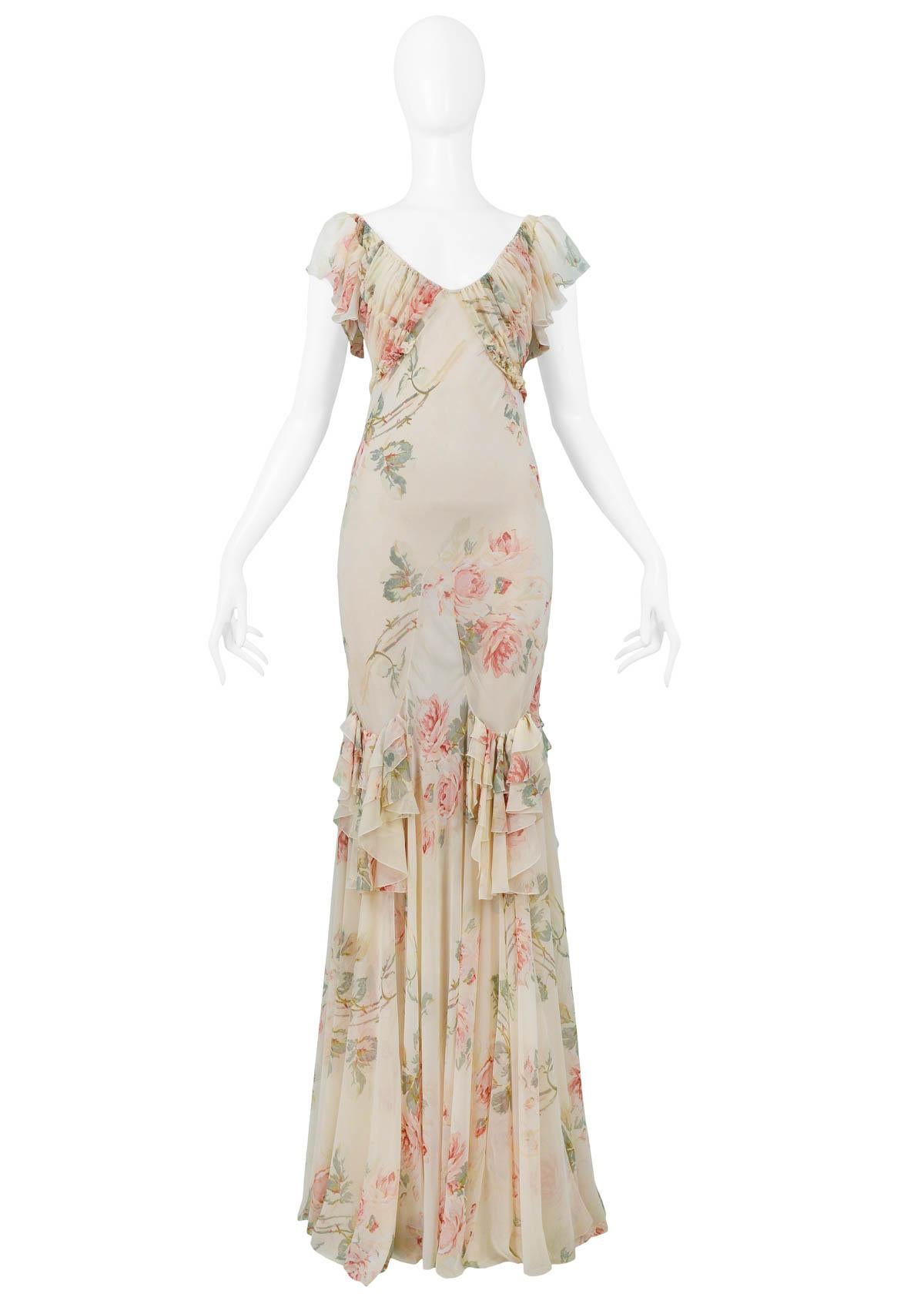 Vintage John Galliano cream floral chiffon bias cut gown featuring flutter sleeves, gathering at bust, ruffle detailing at skirt, and attached sash that ties at the back. Runway piece from the Autumn/Winter 2001 Collection.

Excellent Vintage