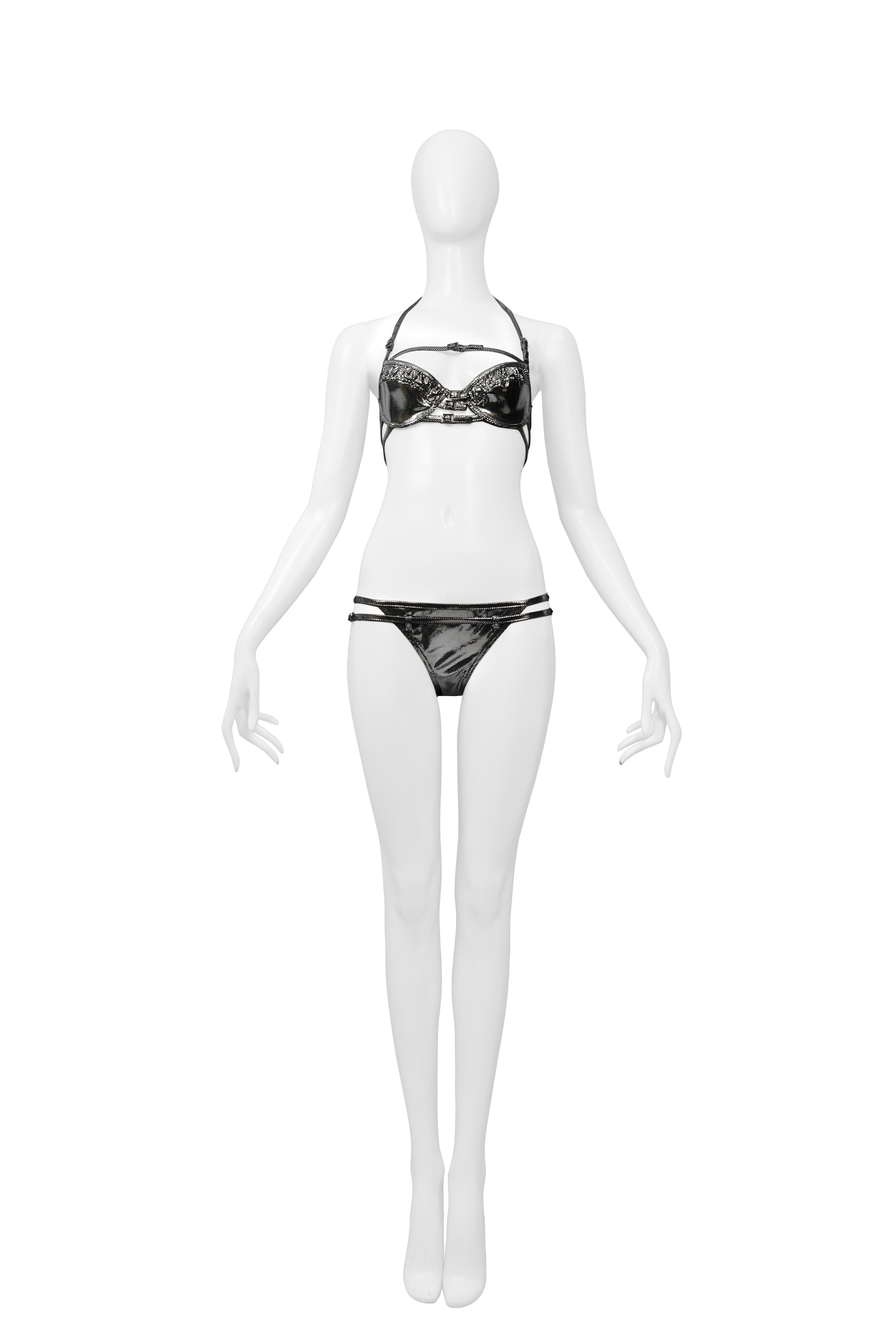Resurrection is excited to offer this vintage Christian Dior silver metallic wet look bikini featuring bondage straps with silver grommets and buckles, hipster bikini bottoms, and black lining. This suit appears unworn. 

Christian Dior