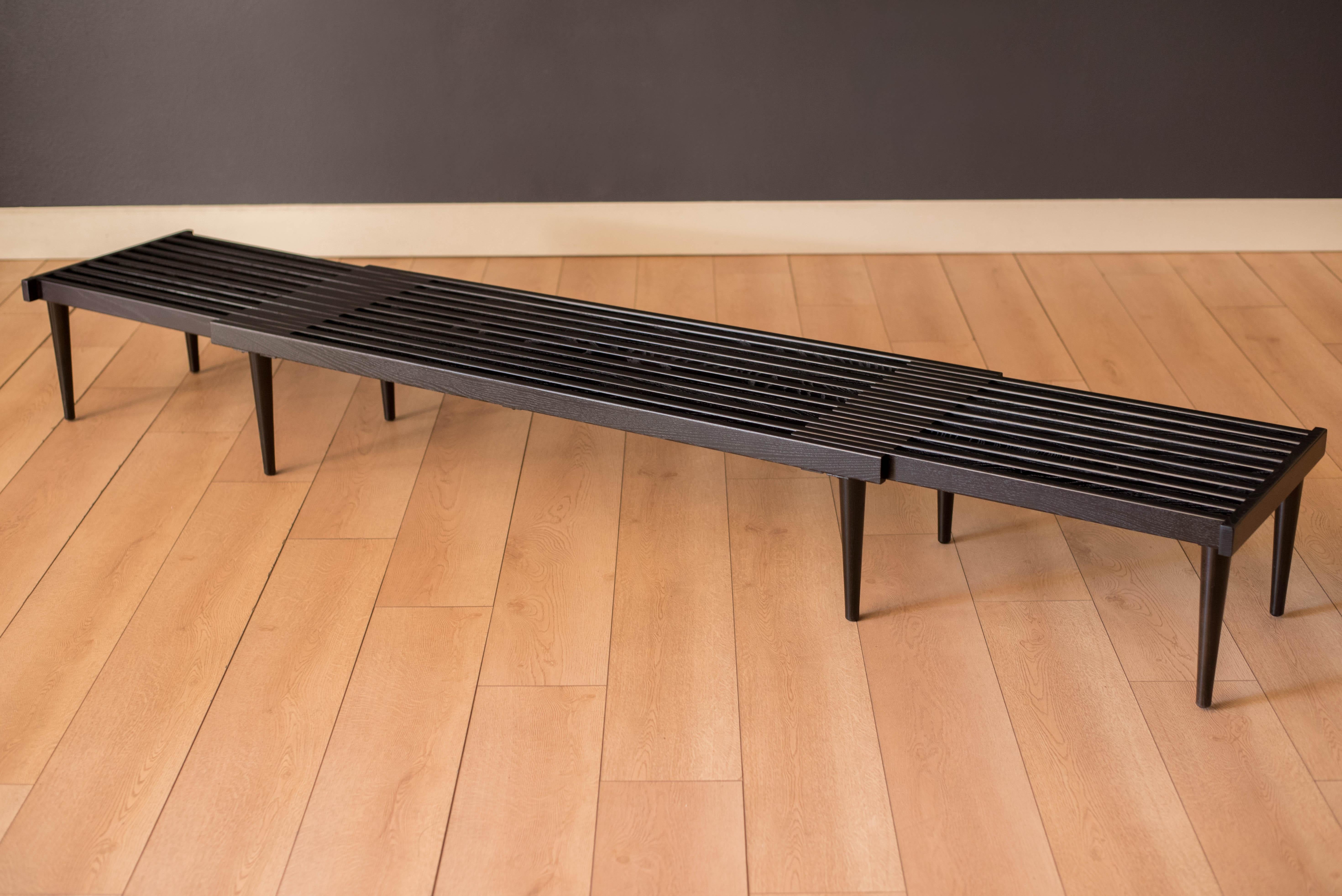 Mid century minimalist slat bench designed by John Keal for Brown Saltman. This versatile California modern piece features an expandable sliding top with eight support legs. Perfect to use as a living room coffee table, entryway or bedroom seating