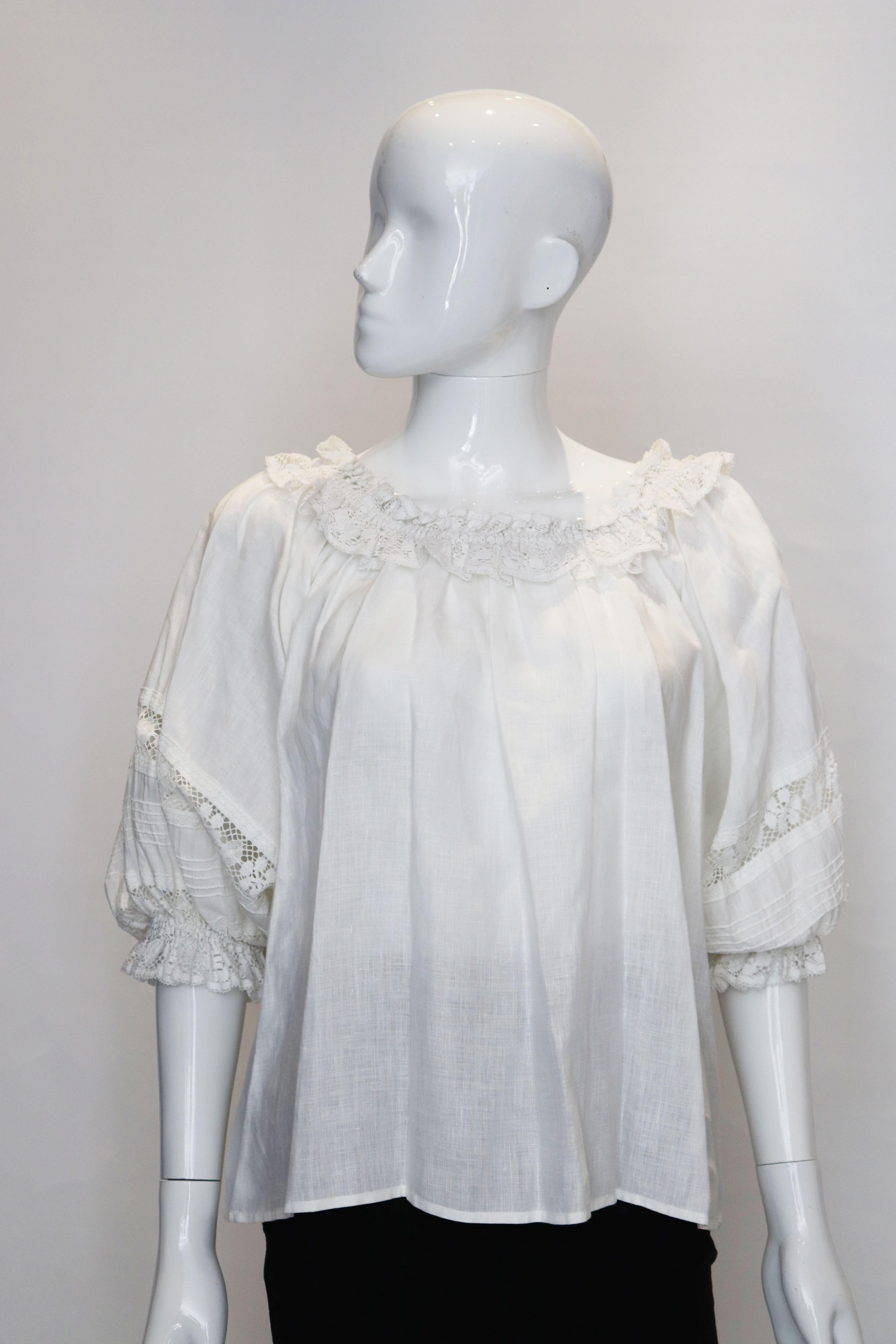 A vintage John Radaelli linen top. The top is off the shoulders with a lace trim and elbow length sleaves with lace detail.
