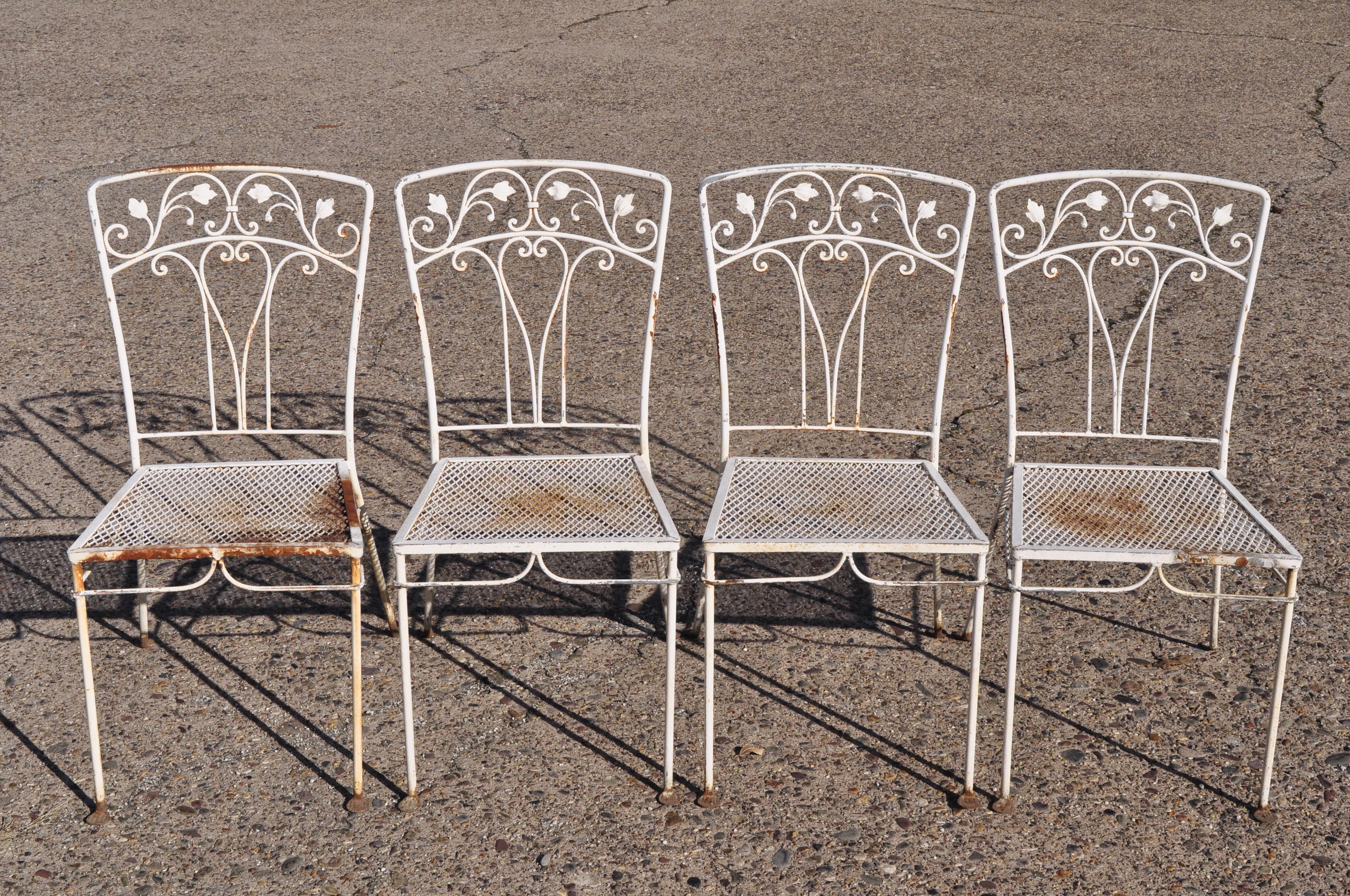 Vintage John Salterini 5-piece leaf and vine wrought iron garden patio dining set. Listing includes (4) dining side chairs, rectangular dining table (no glass), metal mesh seats, rectangle patio table, wrought iron construction, circa mid-20th