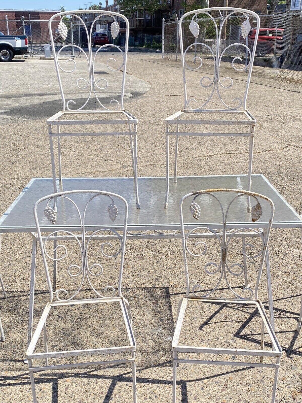 Vintage John Salterini Grape Cluster Wrought Iron Patio Garden Dining Set - 7 Pc Set. Item features a wrought iron scrolling frames with grape cluster design. Set includes (1) Rectangular dining table with glass top, (2) Arm chairs, (4) Side chairs,