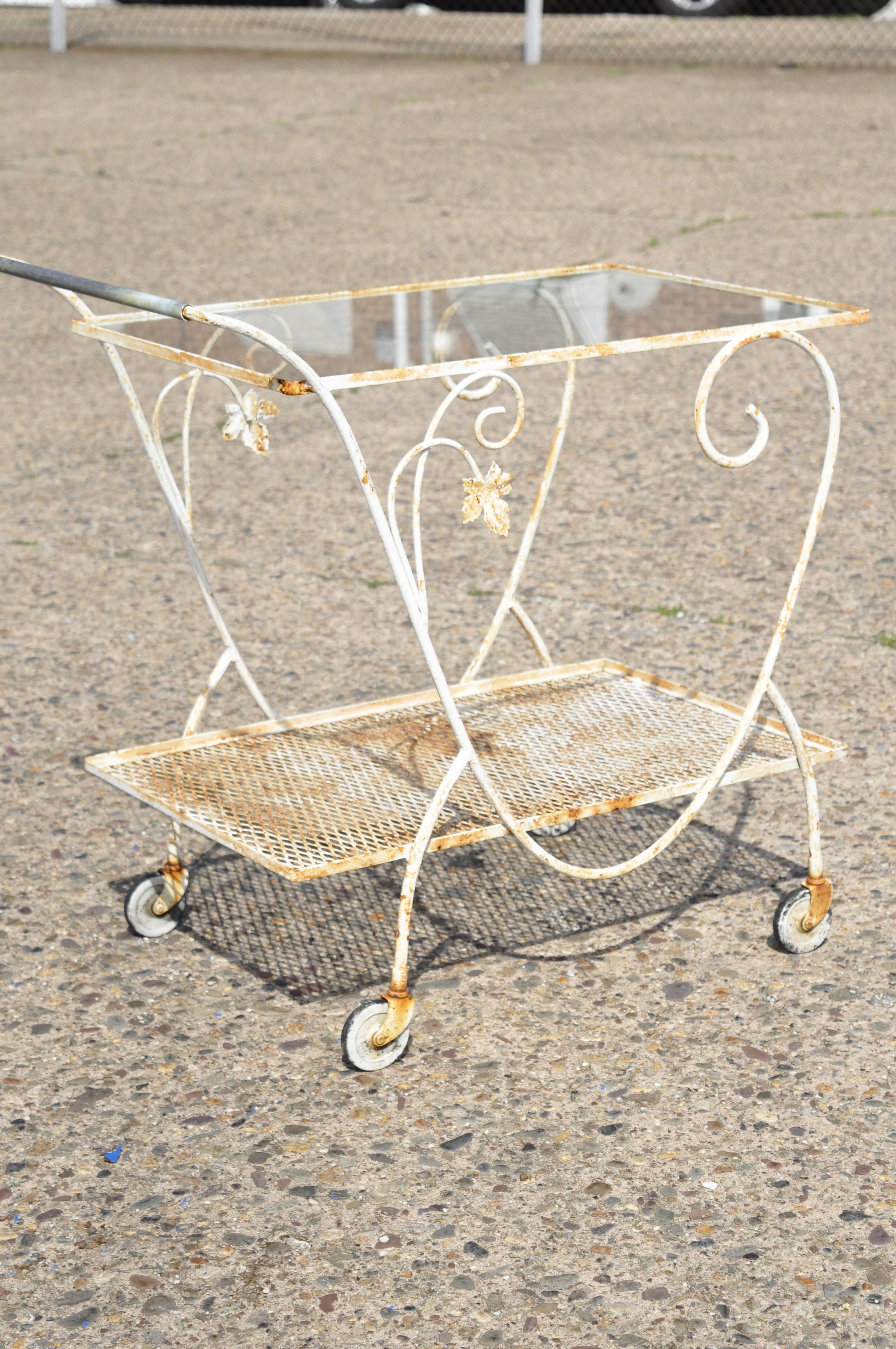 Vintage John Salterini Woodard scrolling leaf vine wrought iron garden bar cart. Item features lower mesh tier, leafy scrollwork, 1 glass shelf, very nice vintage item, quality American craftsmanship, great style and form. Circa mid 20th century.