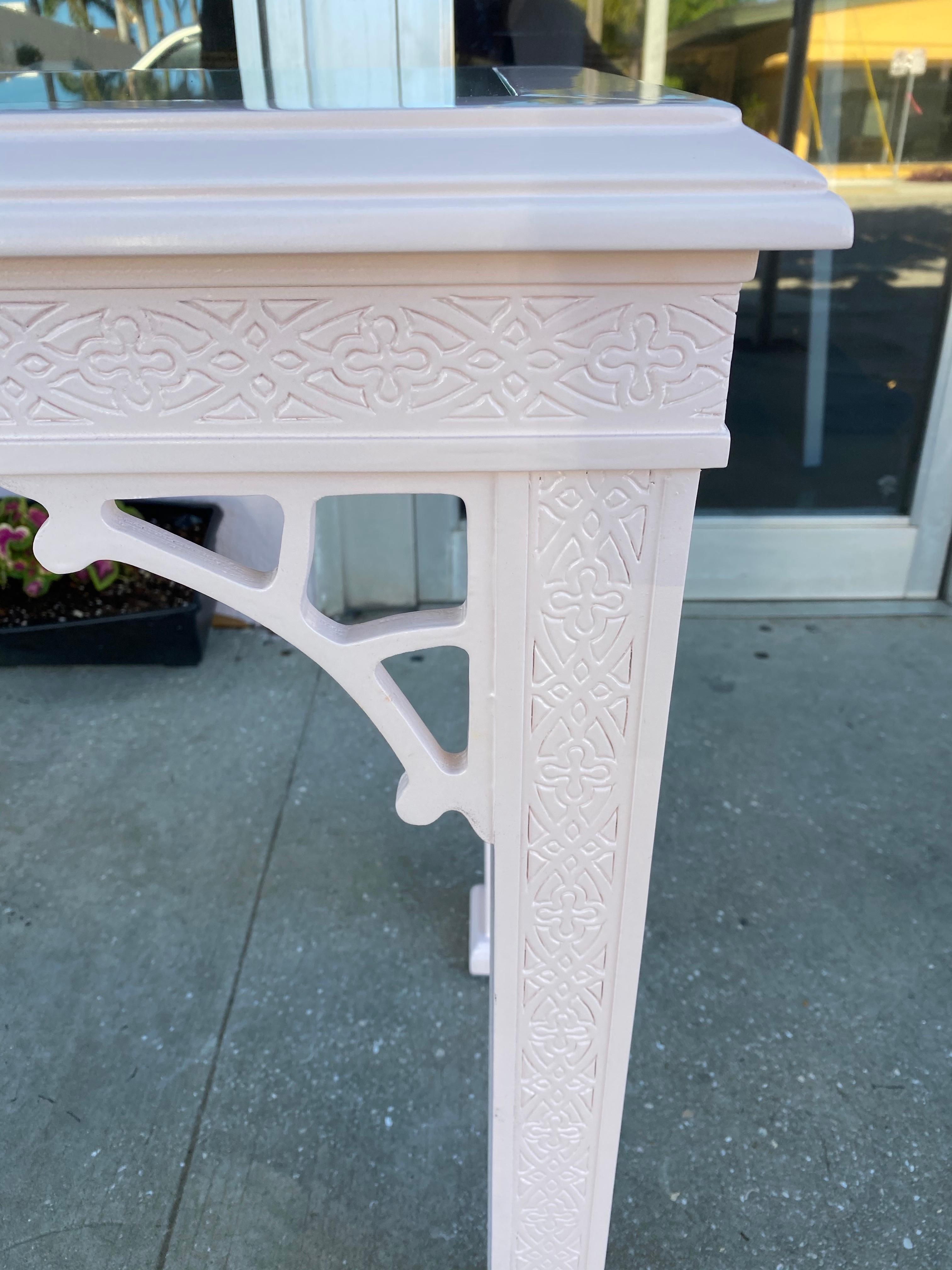 Such a beautiful faint coral, newly lacquered, console table. New glass top. Fretwork details on the legs, skirt, top and sides. This console table is full of beautiful details.