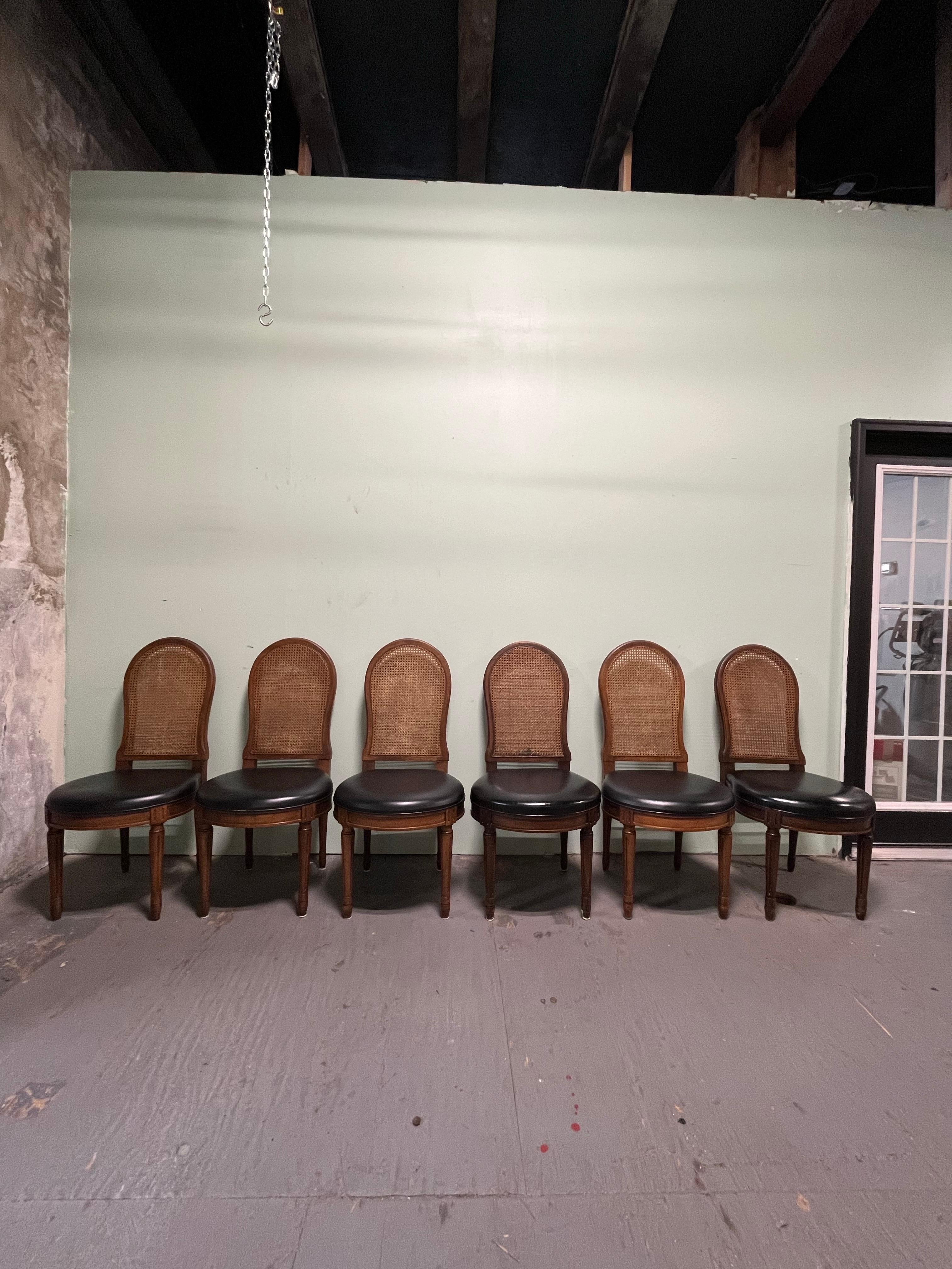 Set of 6 Cane back dining chairs with leather seats. Louis XVI styling. Great design with complimenting warm wood and black leather seat. 