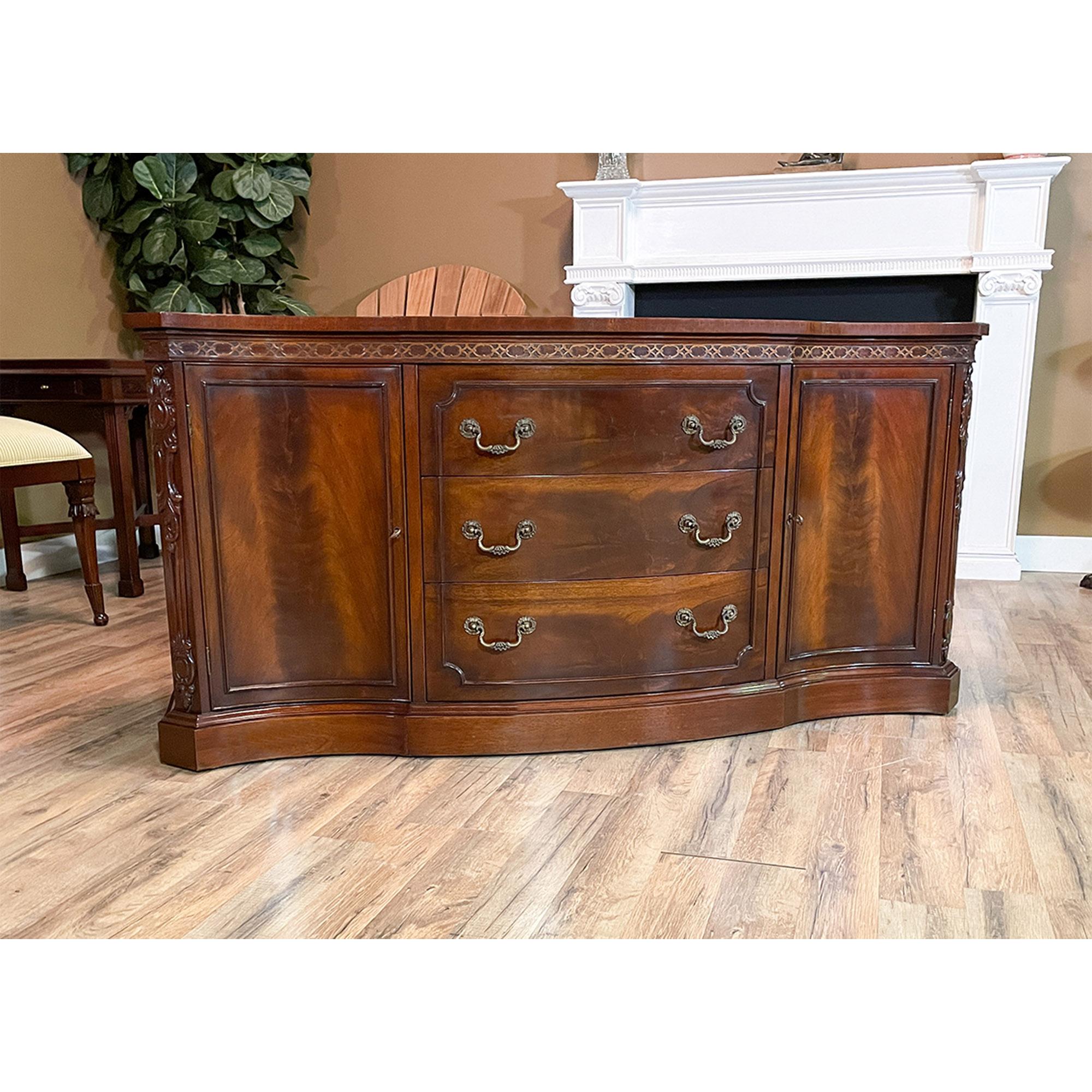 A Vintage John Stuart Two Piece Breakfront with serpentine front. This china closet is impressive in both it’s design and scale. Made of beautifully grained mahogany, the bookcase top features glass shelves as well as solid wood shelves and