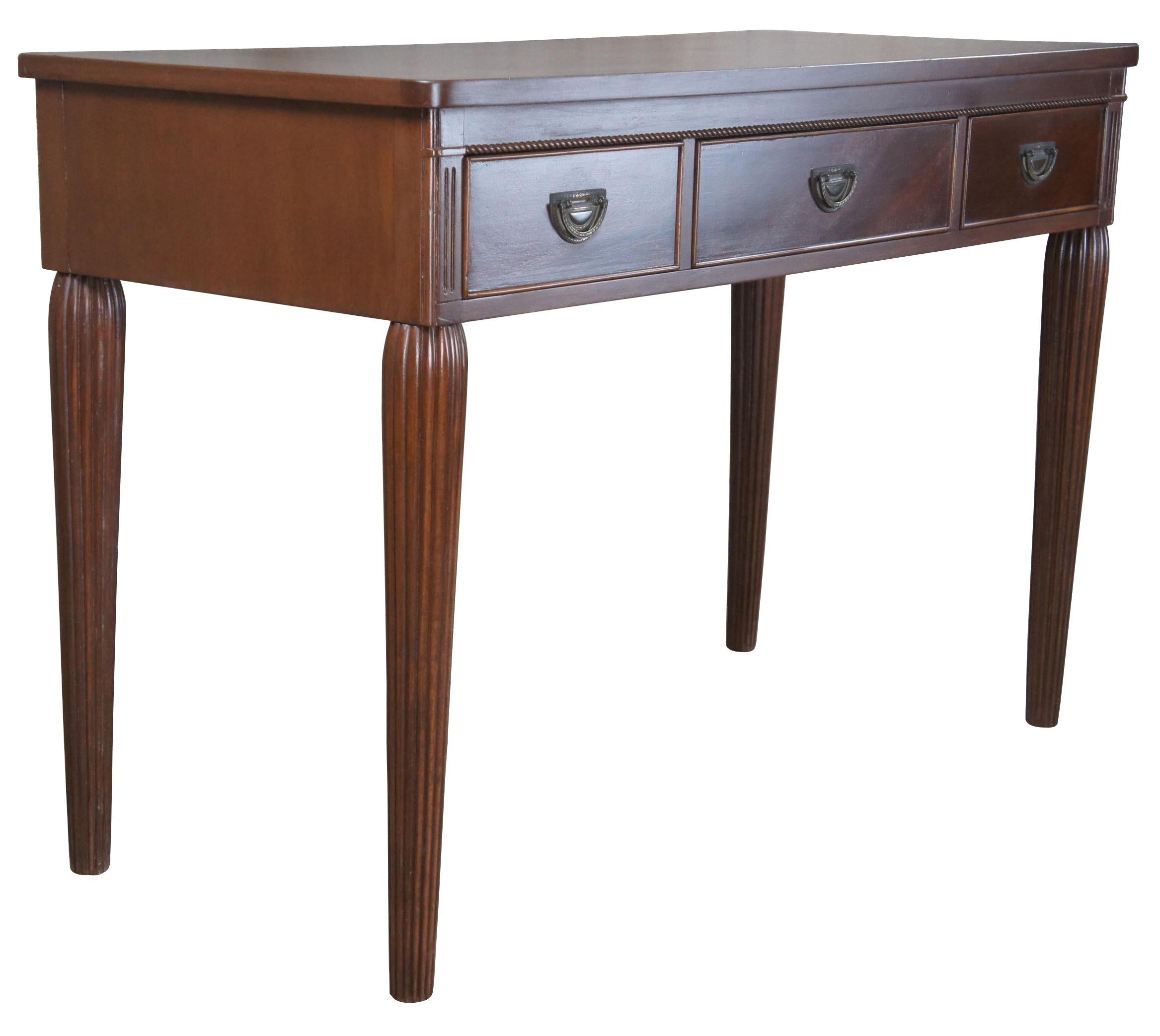 Vintage John Wanamaker library writing desk. Made of mahogany featuring rectangular form with three brass art deco hardware drawers and fluted tapered legs.

John Wanamaker Department Store was one of the first department stores in the United