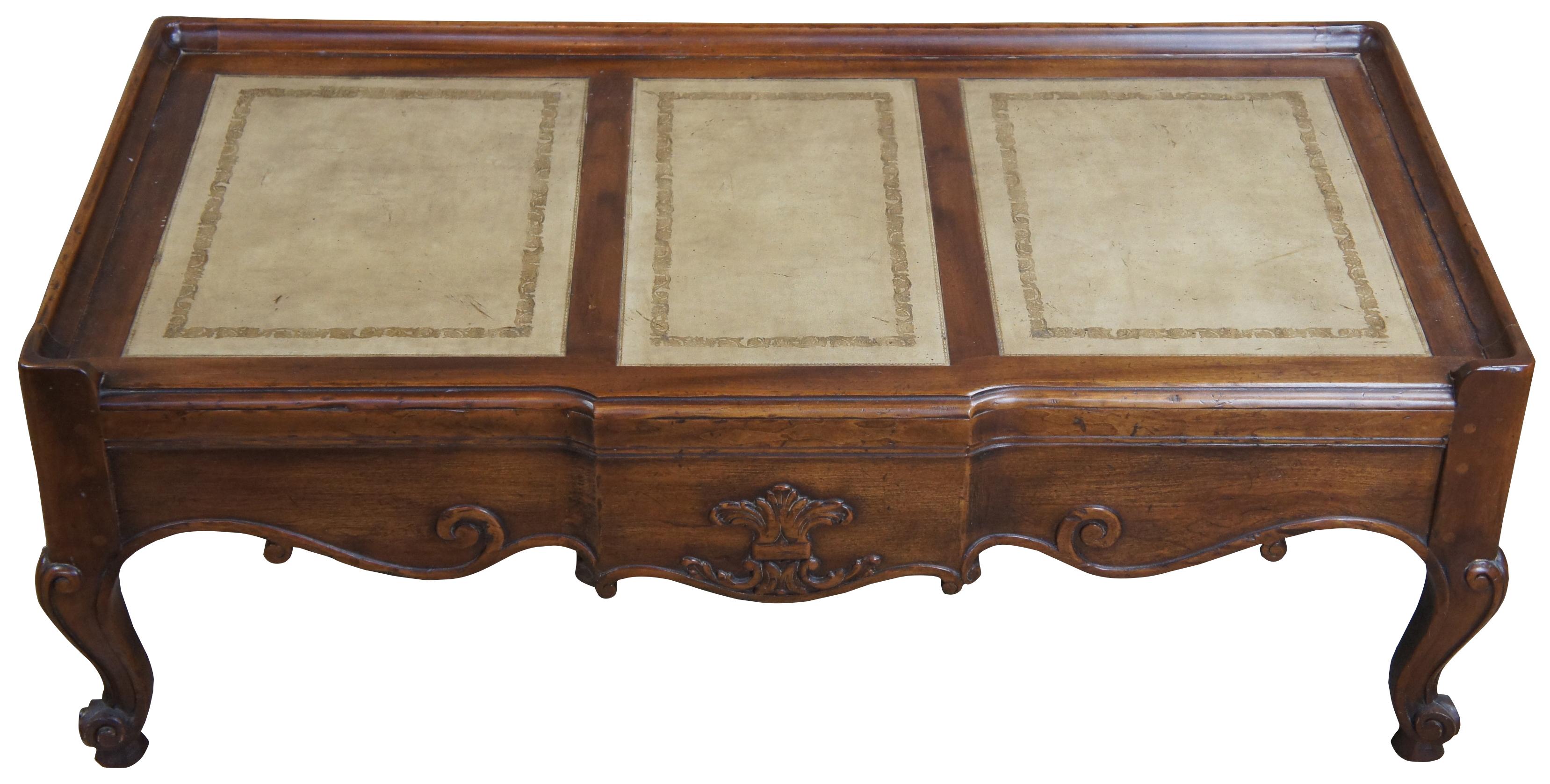 John Widdicomb coffee table, circa 1980s. Made from walnut with carved accents and a tooled leather inset top. Features a rectangular form over cabriole legs. Draws inspiration from Louis XV and Provincial styling. John Widdicomb of Grand Rapids,