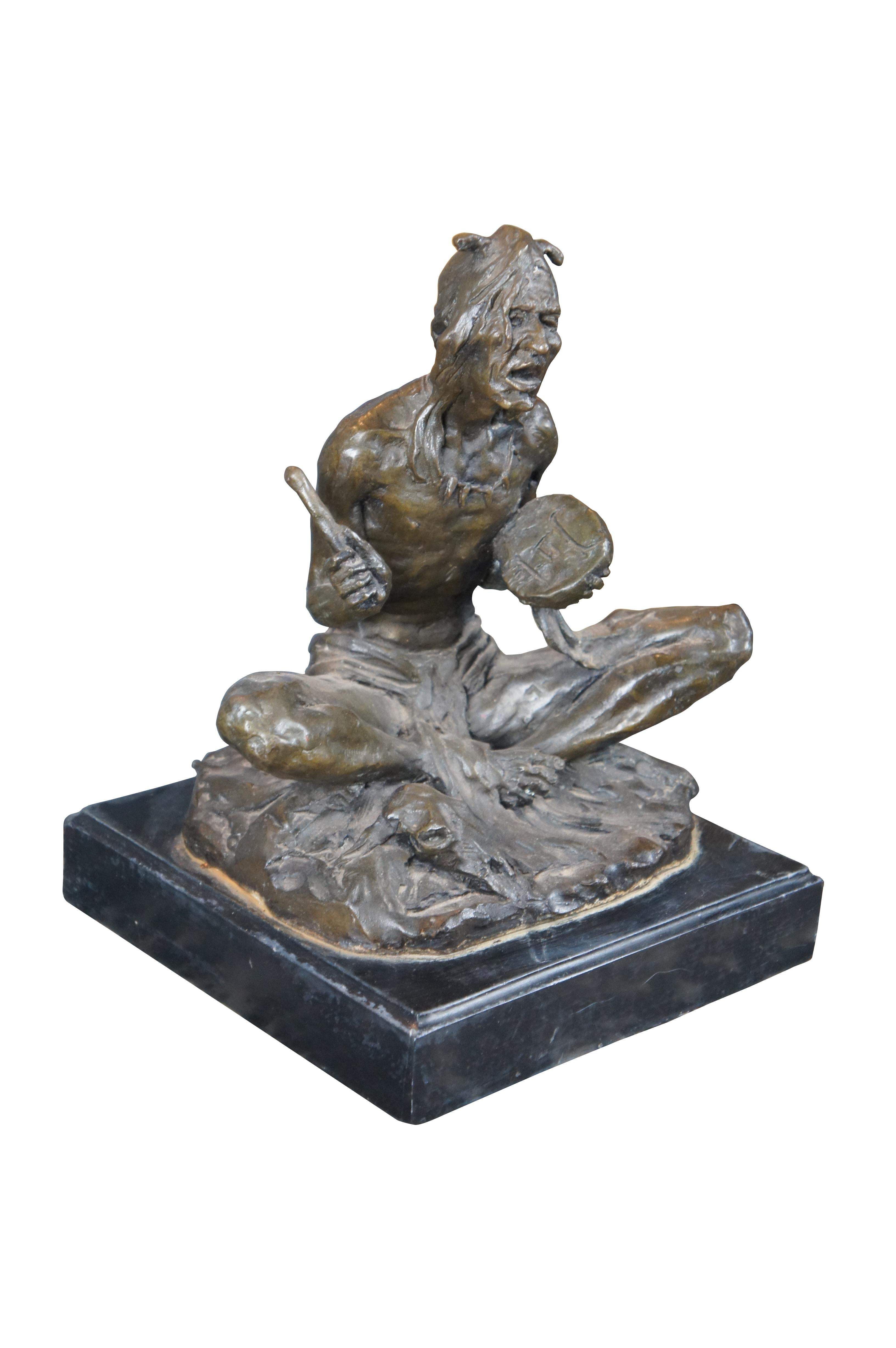 A 20th Century bronze featuring a Native American Chief sitting Indian style while playing the drum and singing. The chief is sitting next to a cow scull and raised over a plinth base. Signed by Jon Rubin

Dimensions:
9