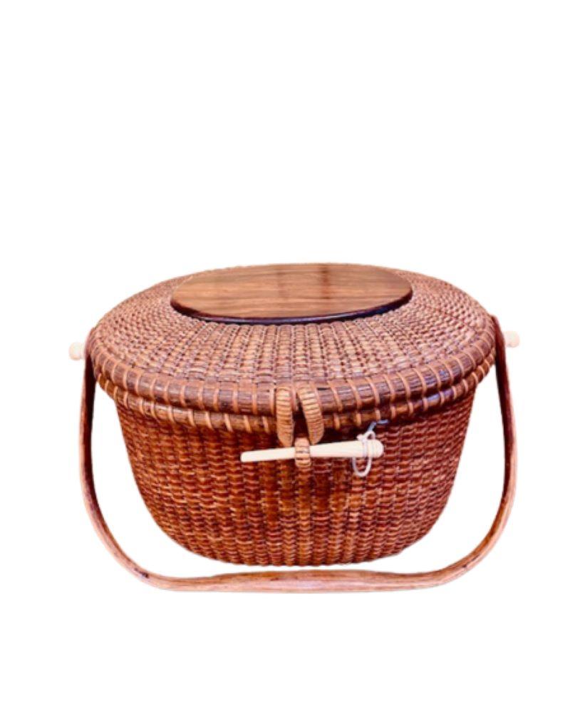 Vintage Jose Reyes Nantucket Purse with Rosewood Top, circa 1960s, an oval cane woven covered basket with fine rosewood top plate, shaped swing handle, carved bone peg and handle attachments. The basket is signed on the bottom with engraved outline