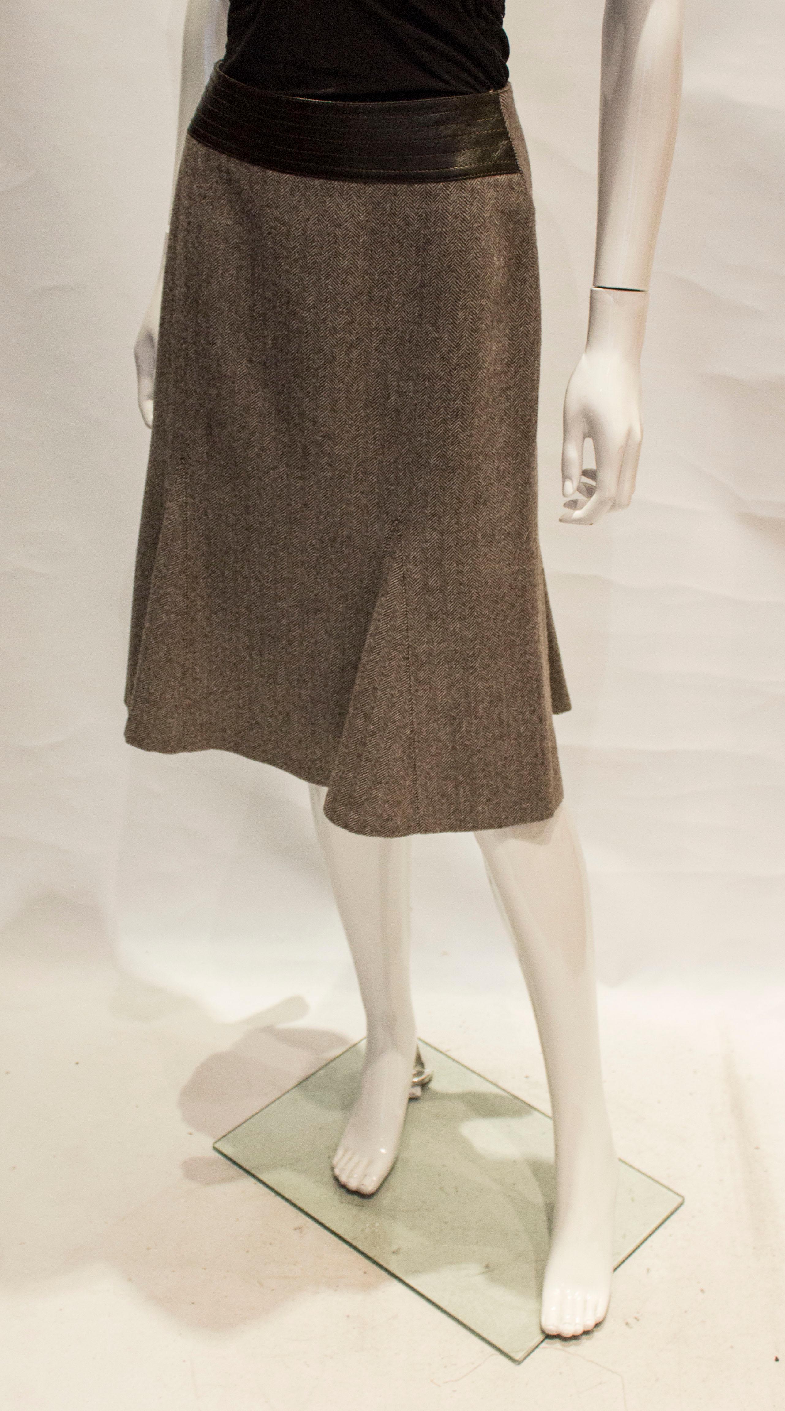 A great vintage skirt suit by joseph. In a brown wool herrngbone , the skirt is flared at the hem and has an interesting leather waistband at the back. It is marked a size M and is fully  lined.
Waist 30 '', length 26''

The jacket has a one button
